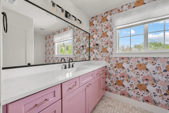 Bathroom with wallpapered walls and vanity