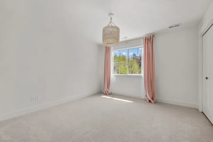 Empty room featuring carpet flooring and baseboards
