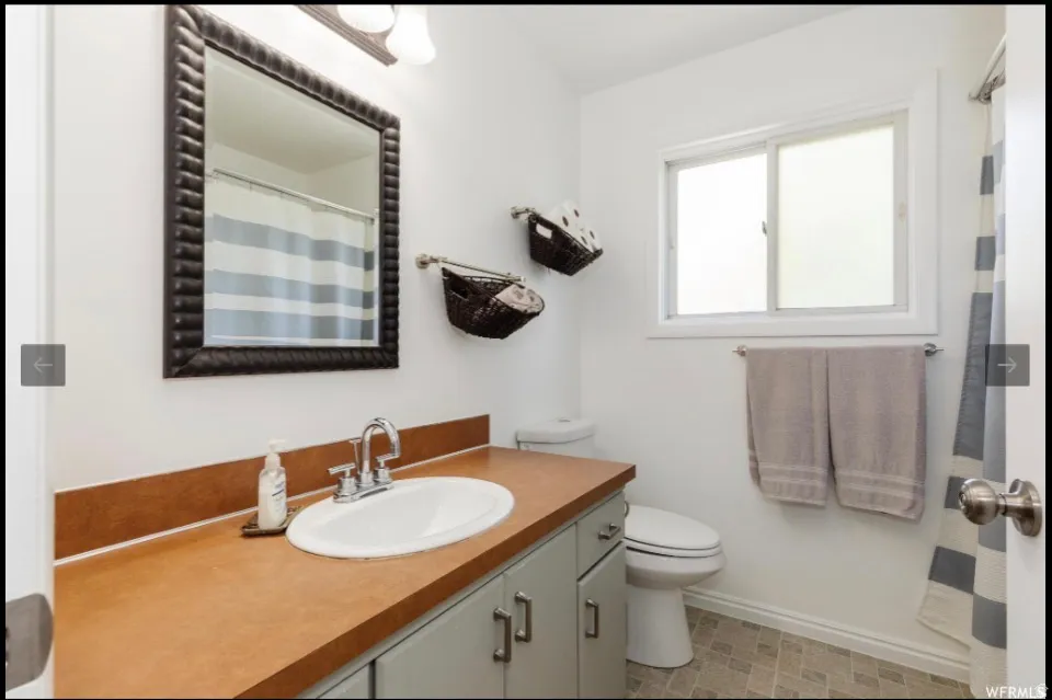 Full bathroom featuring vanity and curtained shower