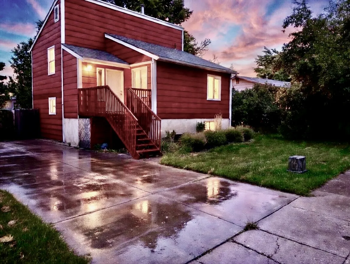 View of front of property featuring a front yard, roof with shingles, and concrete driveway