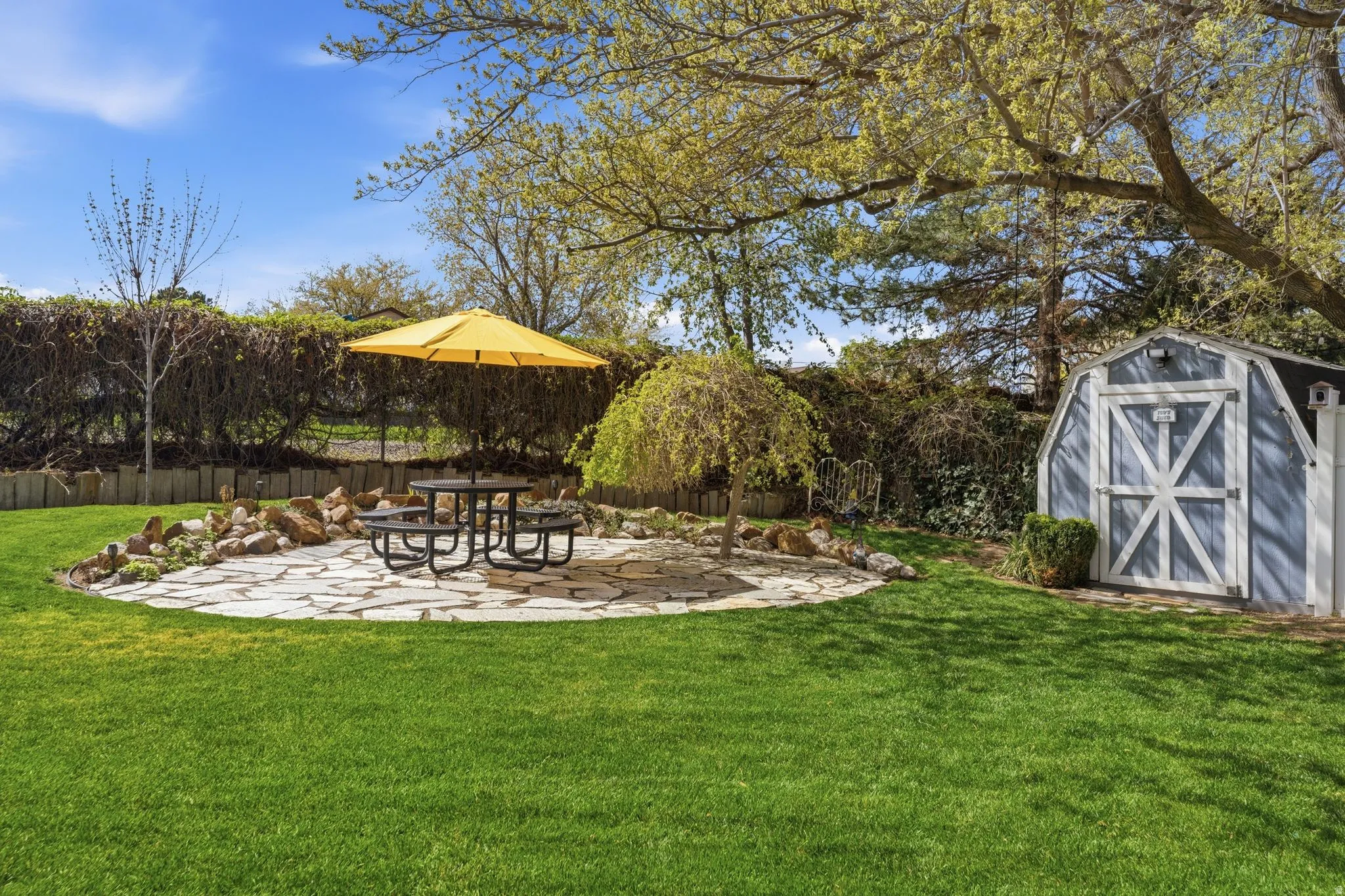 Fenced backyard with a patio area and a shed
