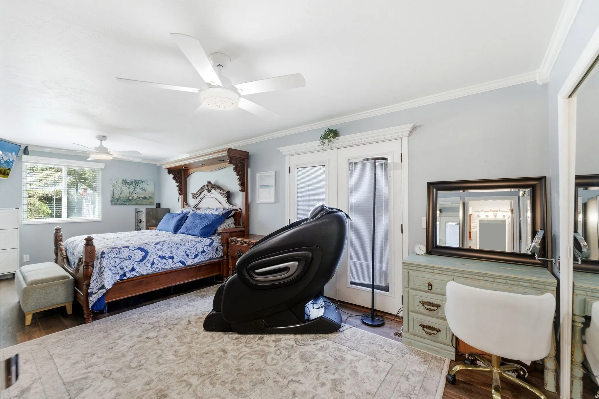 Bedroom with dark wood finished floors, ornamental molding, and a ceiling fan