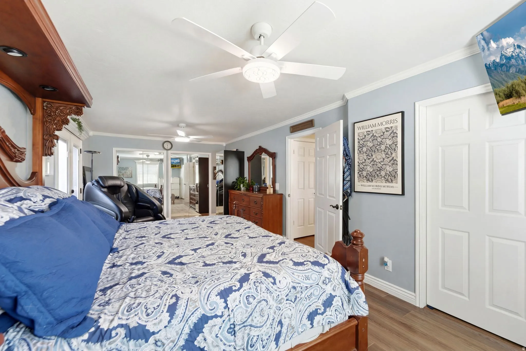 Bedroom with crown molding, a ceiling fan, a closet, and light wood-type flooring
