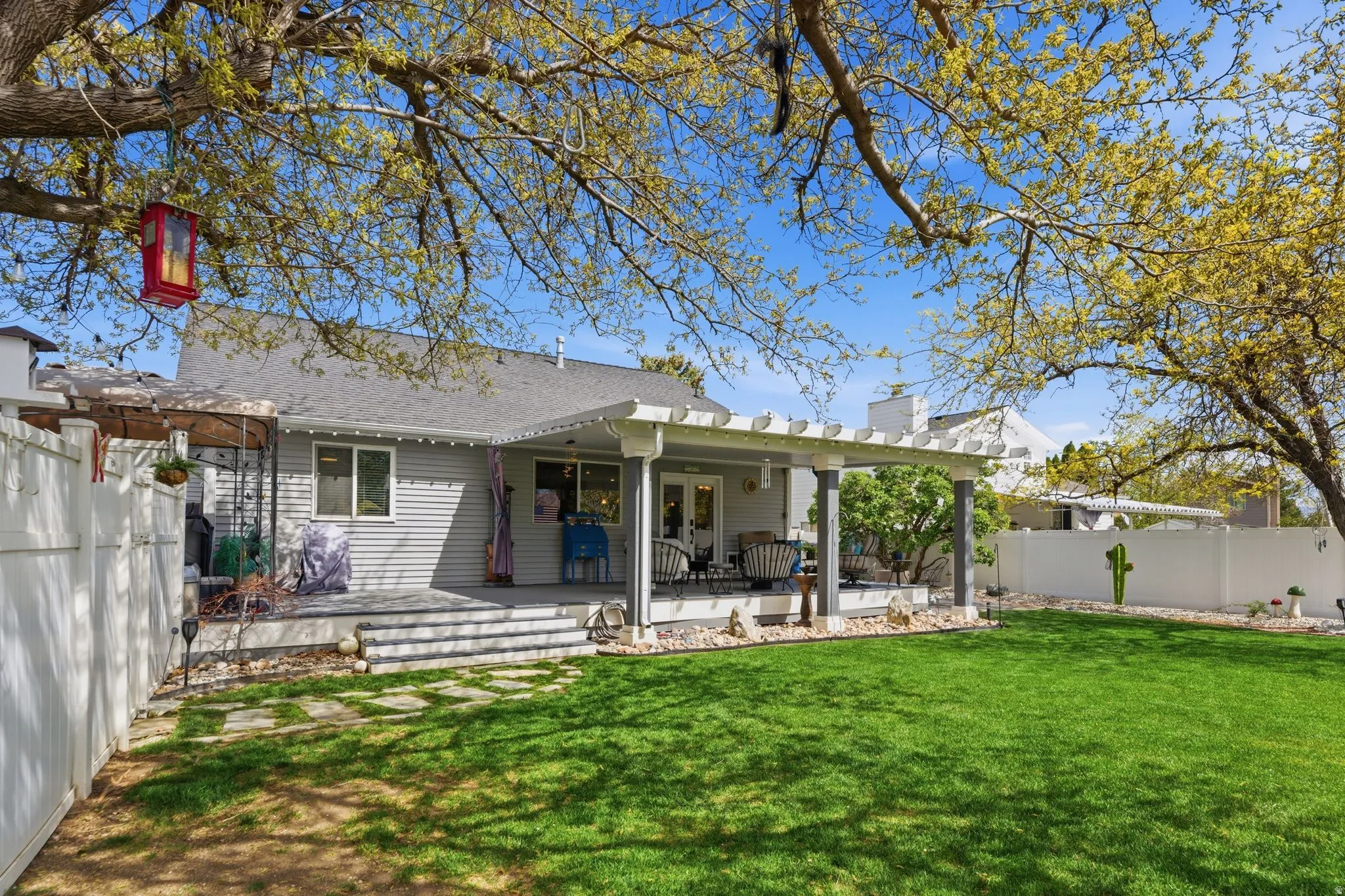 Rear view of property with a fenced backyard, a patio area, a chimney, and roof with shingles