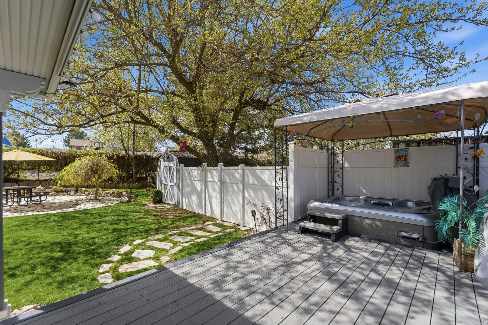 Wooden deck featuring a fenced backyard, a gazebo, a patio area, and a storage shed