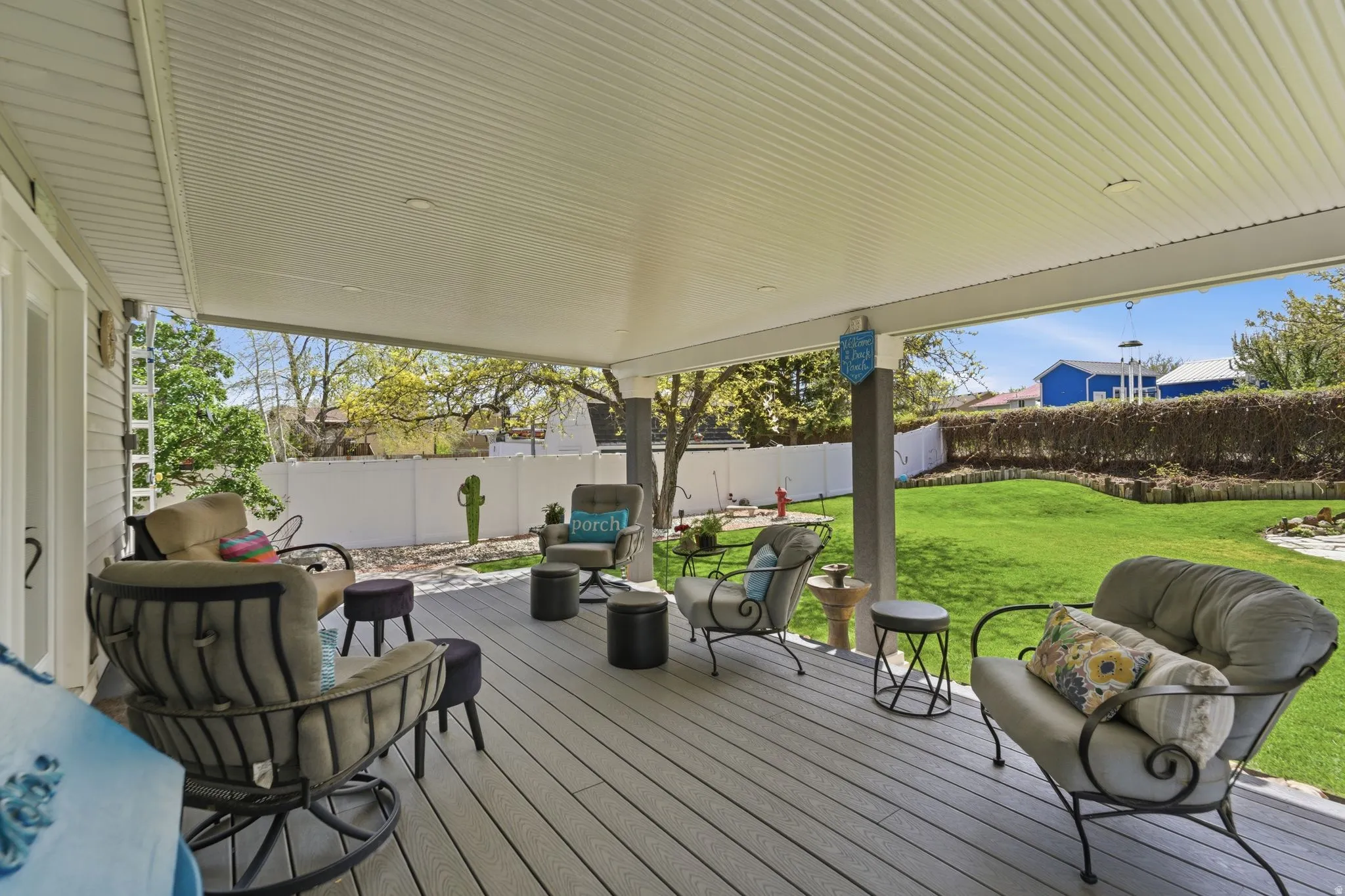 Wooden terrace with a fenced backyard and outdoor furniture