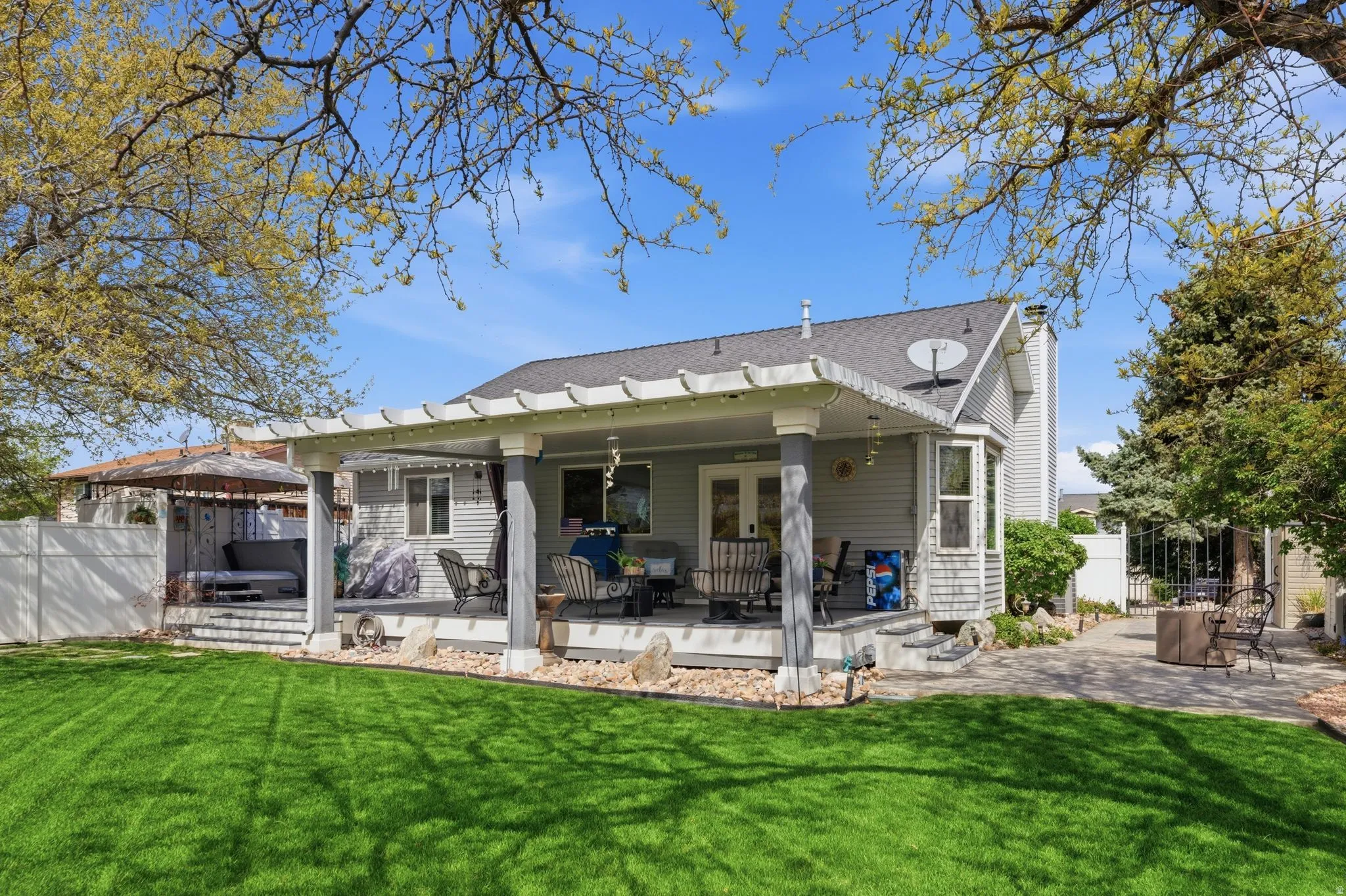 Rear view of property with a patio area, roof with shingles, and a deck