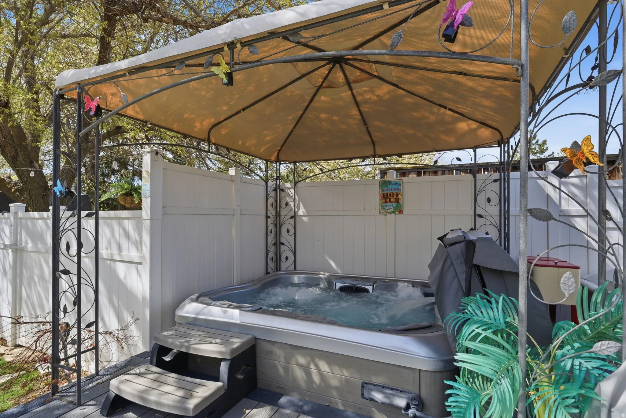 Fenced backyard featuring a hot tub