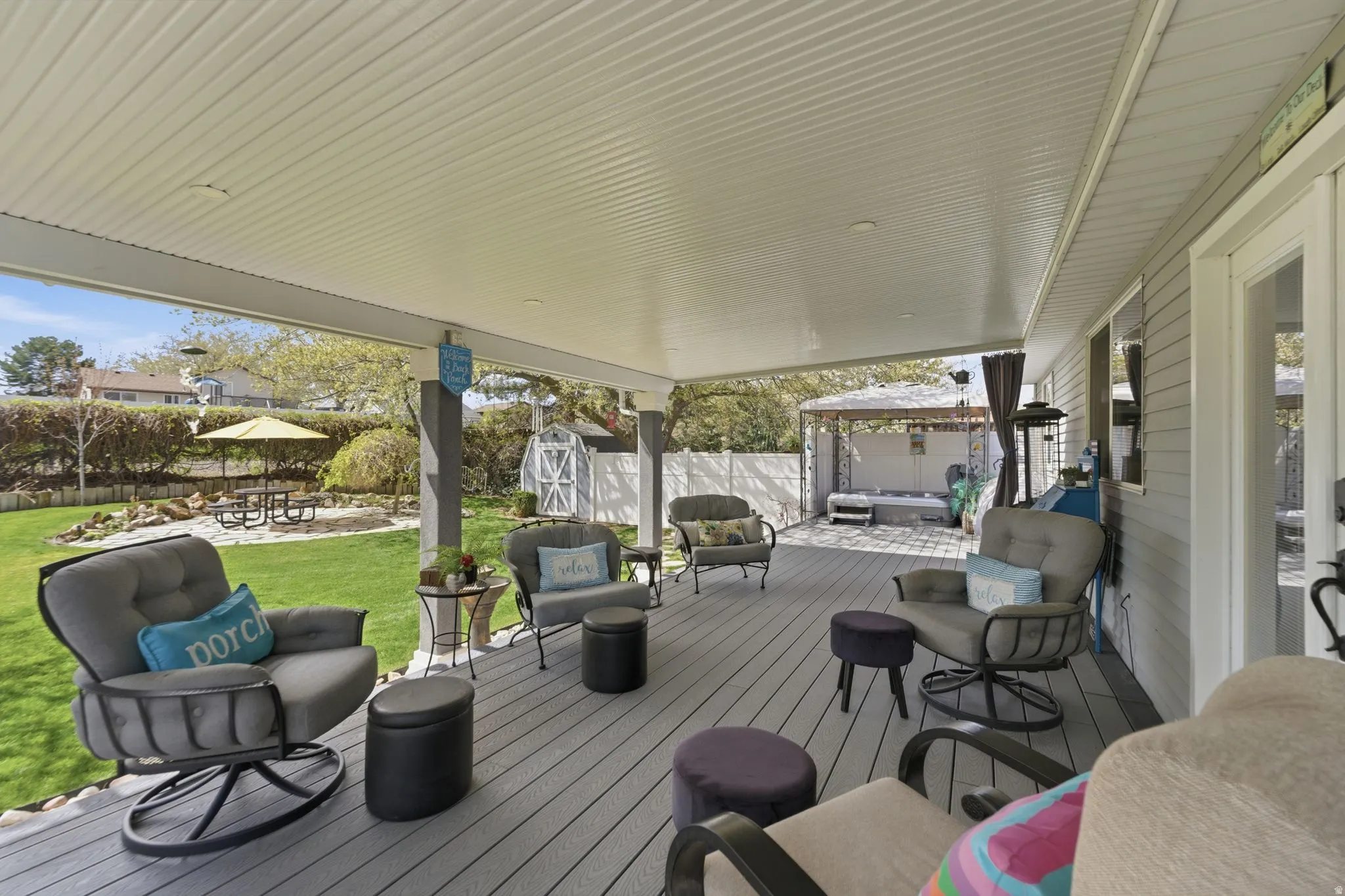 Wooden terrace featuring outdoor furniture, a fenced backyard, and a storage unit