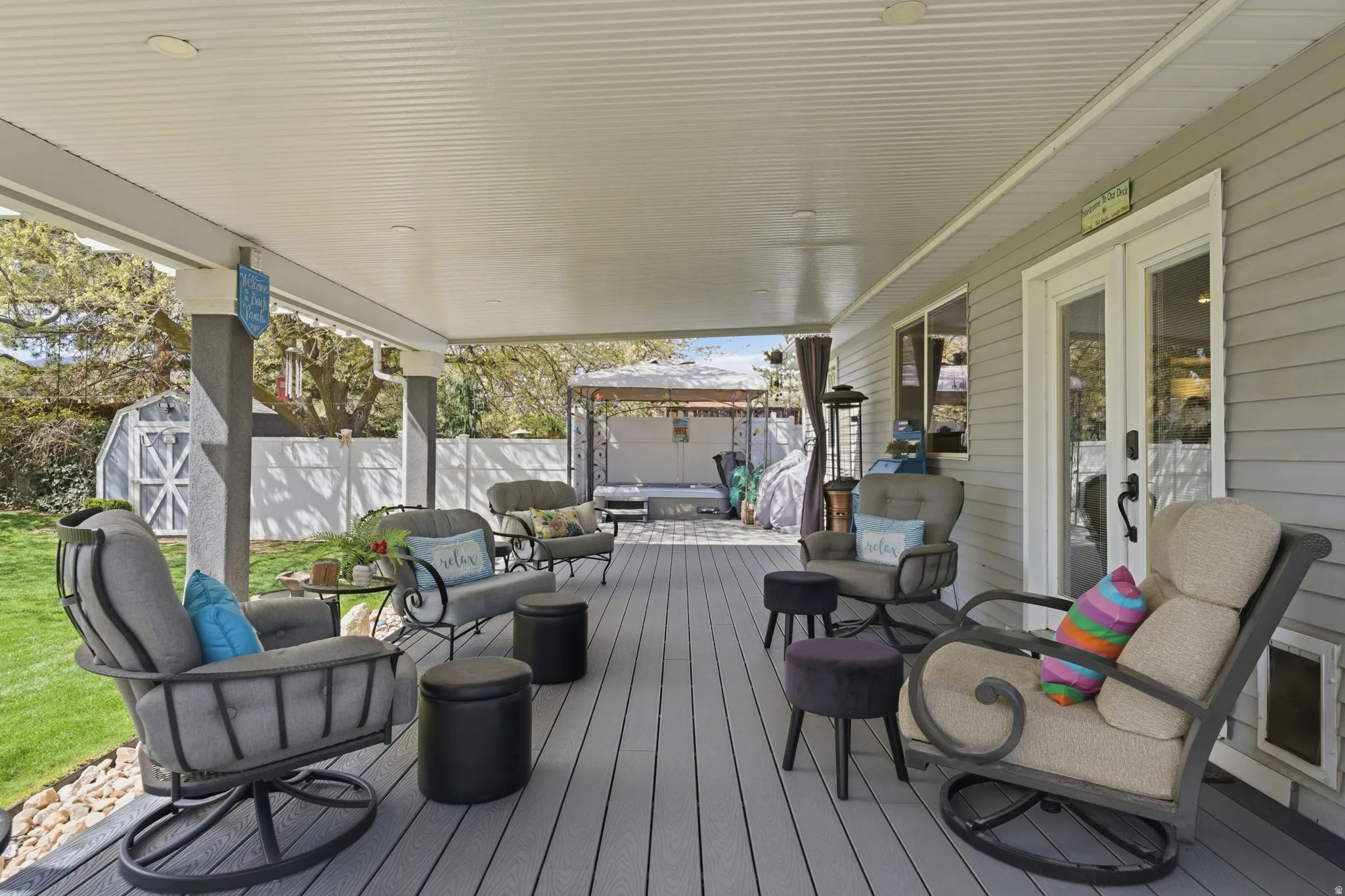 Wooden deck featuring outdoor lounge area, a fenced backyard, french doors, a storage shed, and a gazebo