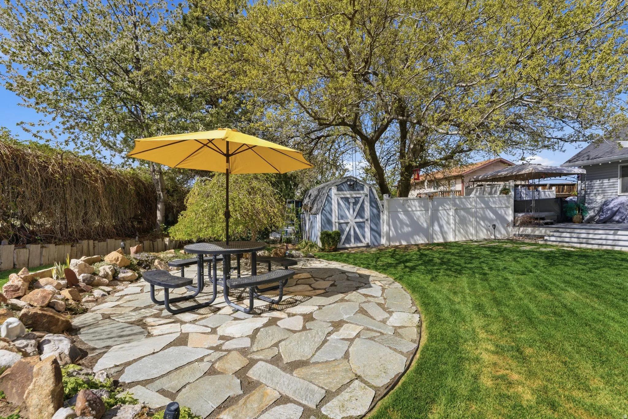 Fenced backyard featuring outdoor dining space, a patio area, and a storage shed