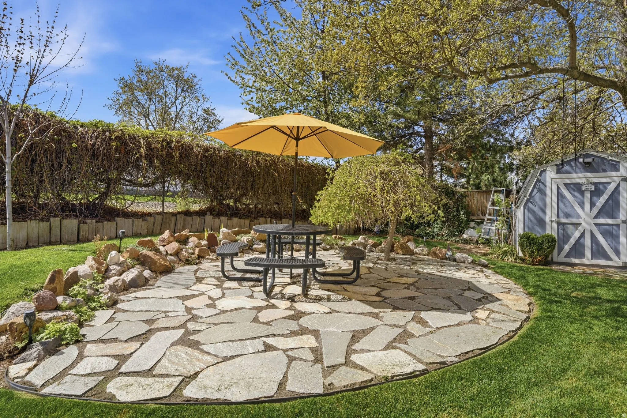 Fenced backyard featuring outdoor dining area, a patio, and a storage unit