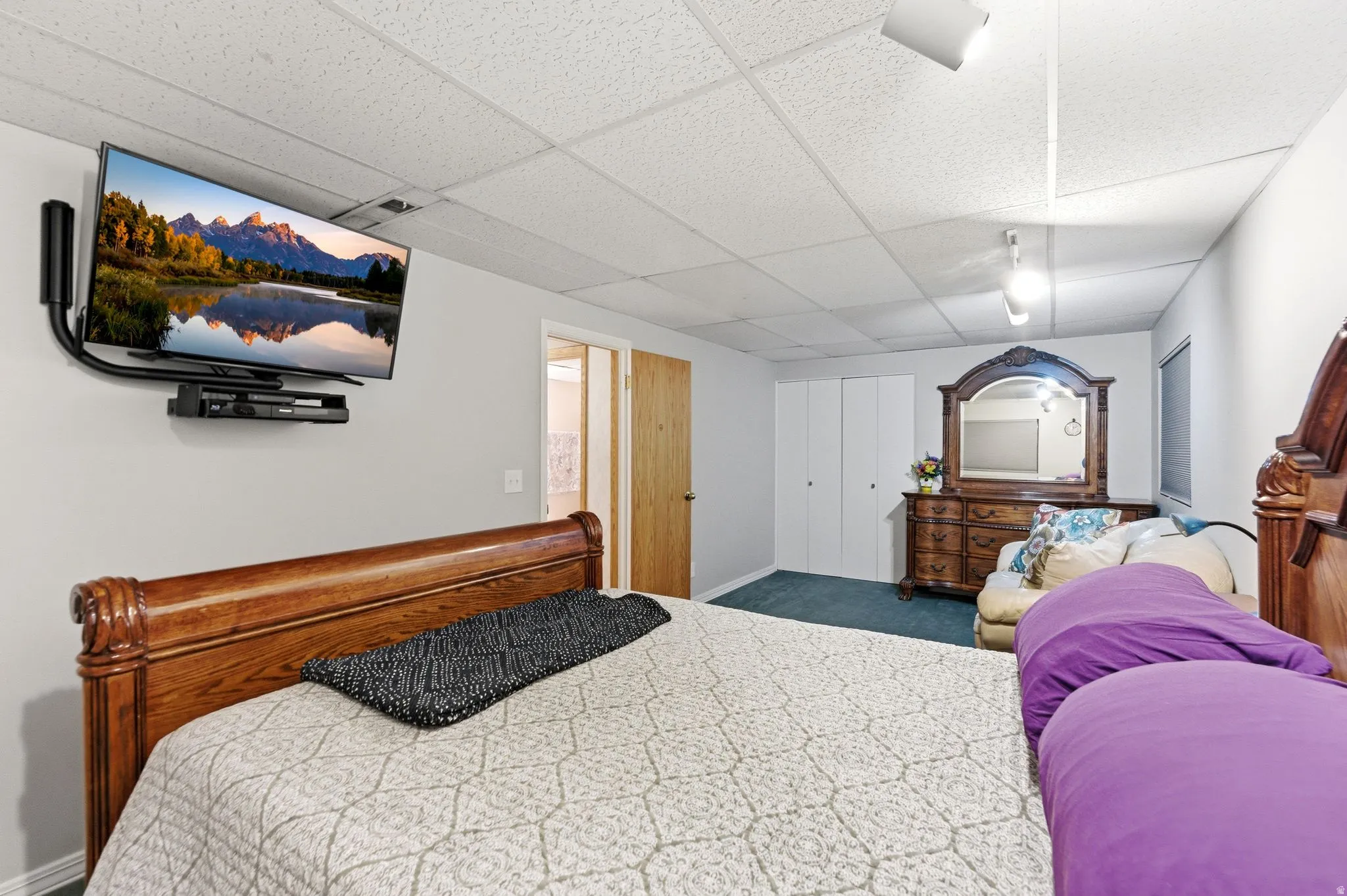 Bedroom with a drop ceiling and dark carpet