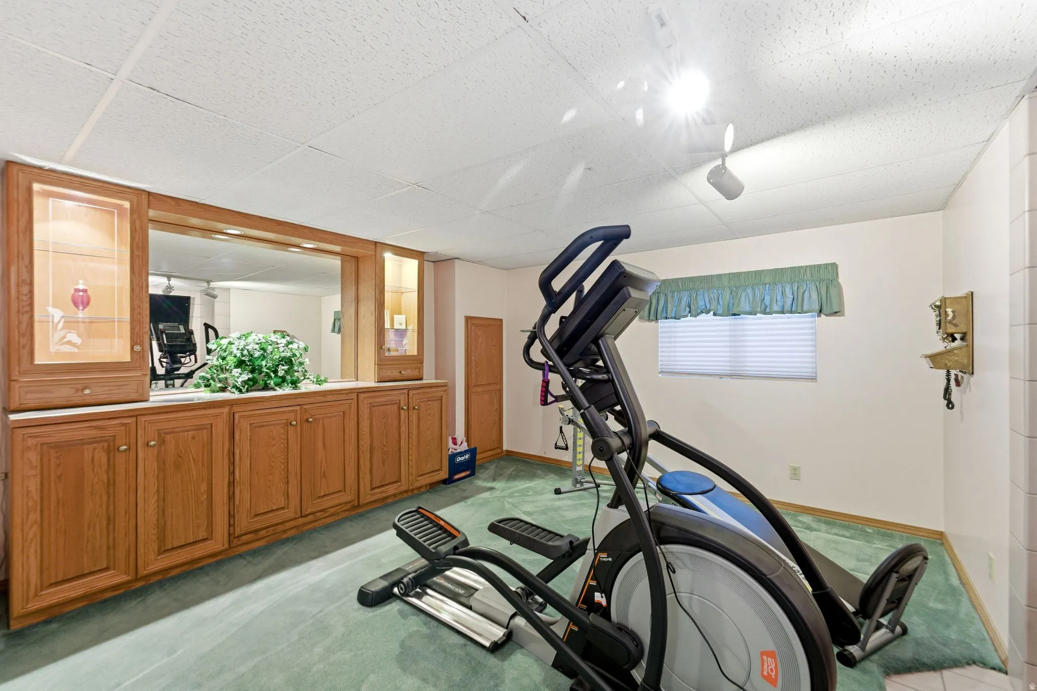 Workout room featuring light colored carpet and a paneled ceiling