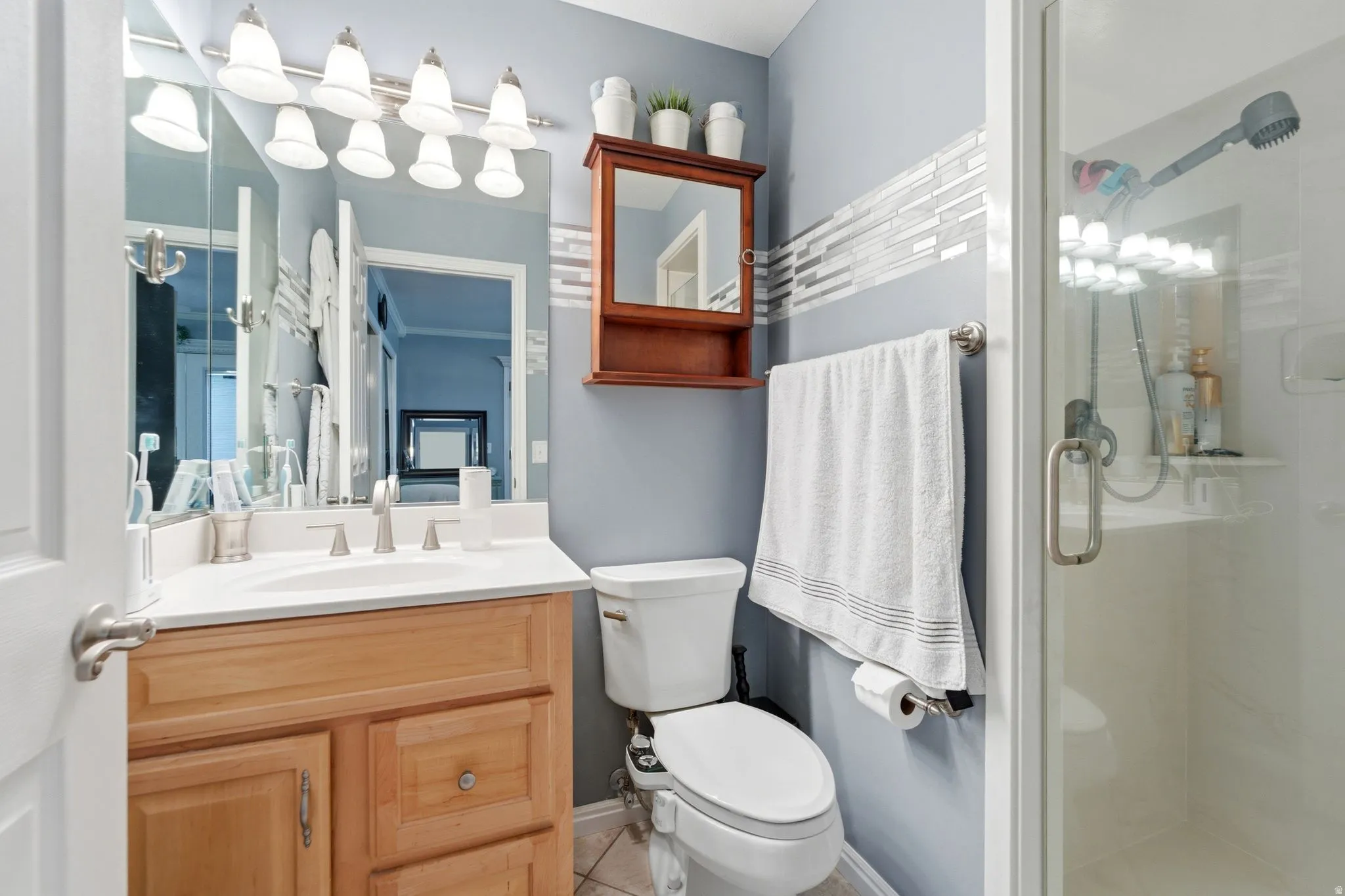 Bathroom with vanity, a stall shower, and light tile patterned flooring