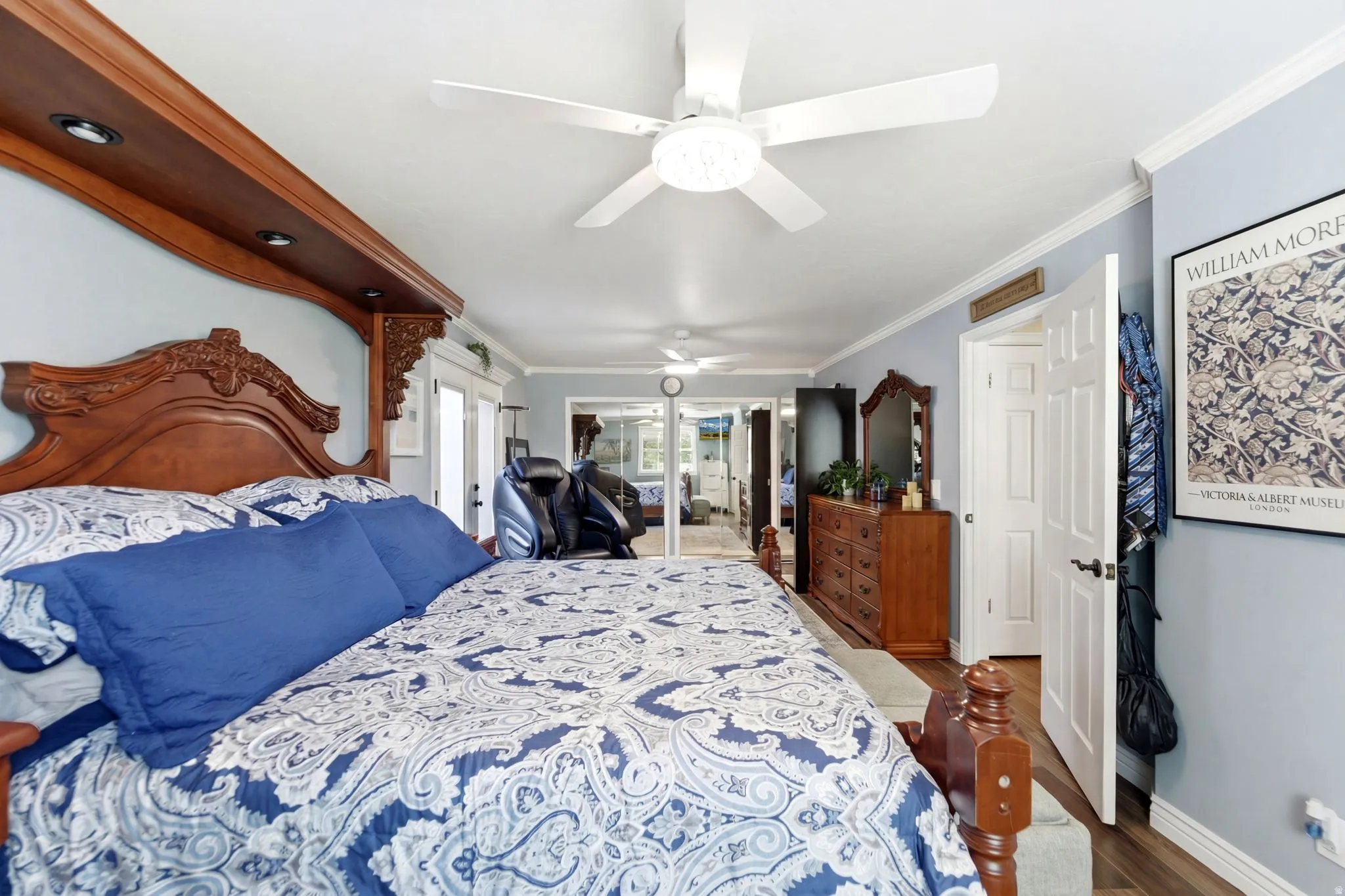 Bedroom featuring ornamental molding, dark wood finished floors, access to exterior, and a ceiling fan