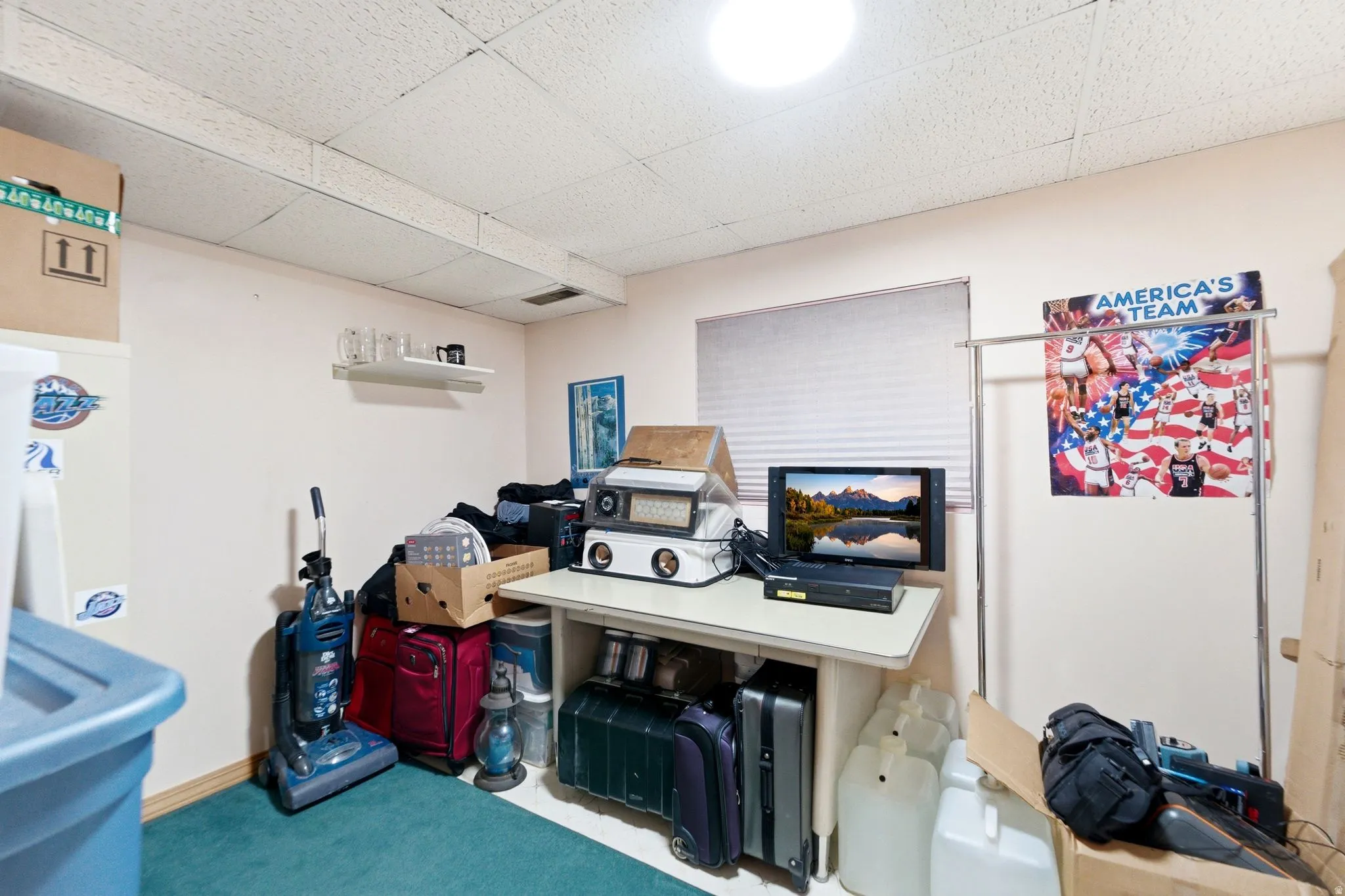 Home office featuring a drop ceiling and light colored carpet