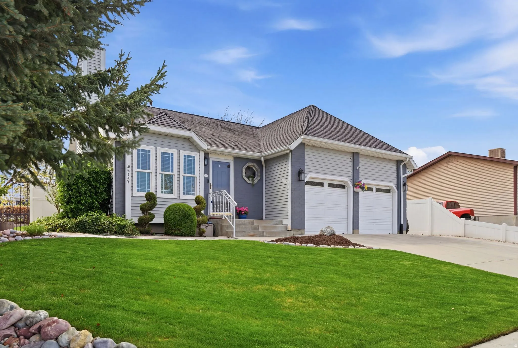 Ranch-style home featuring an attached garage, concrete driveway, and a shingled roof