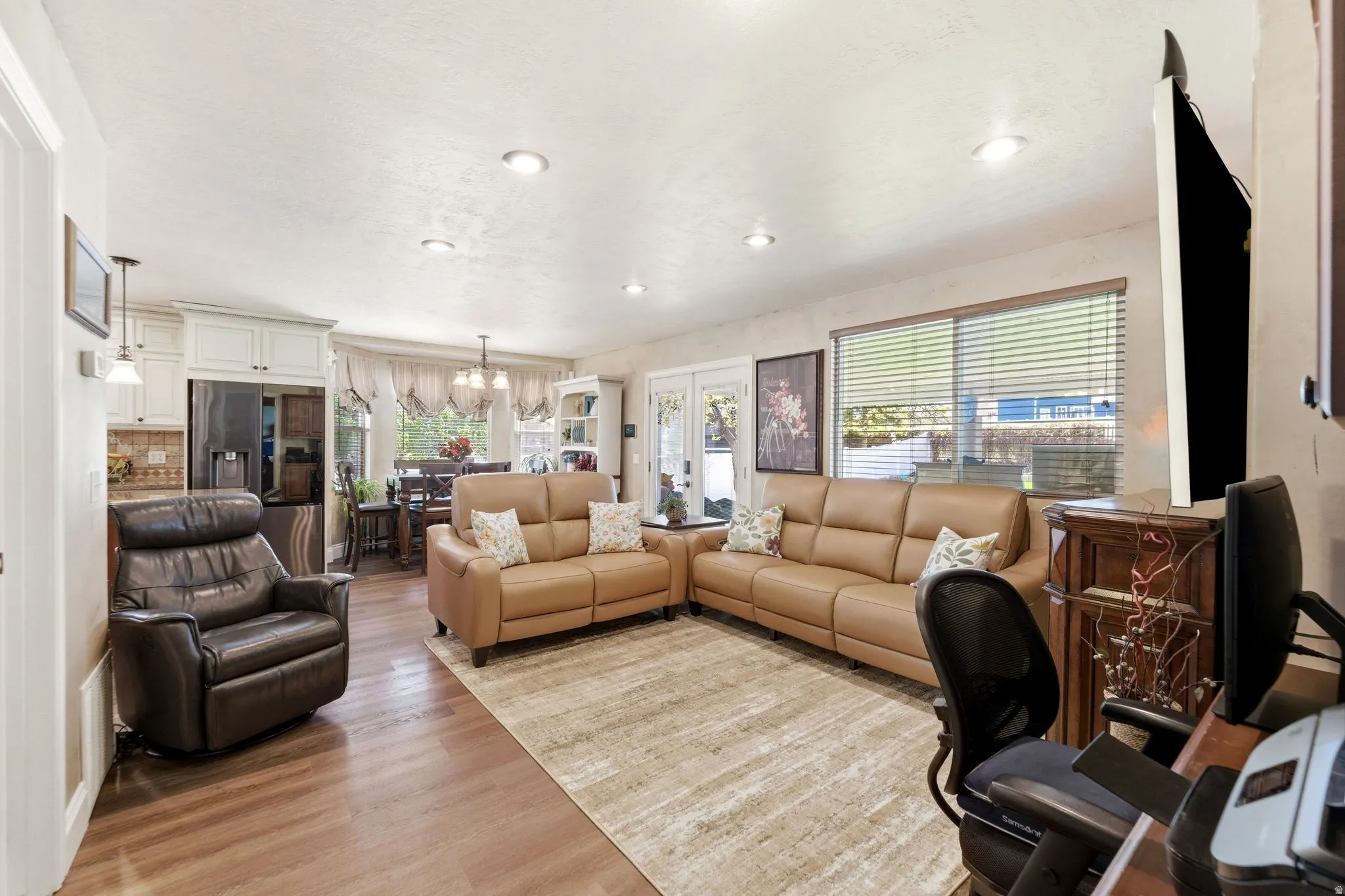 Living room featuring light wood-style floors and suspended lighting