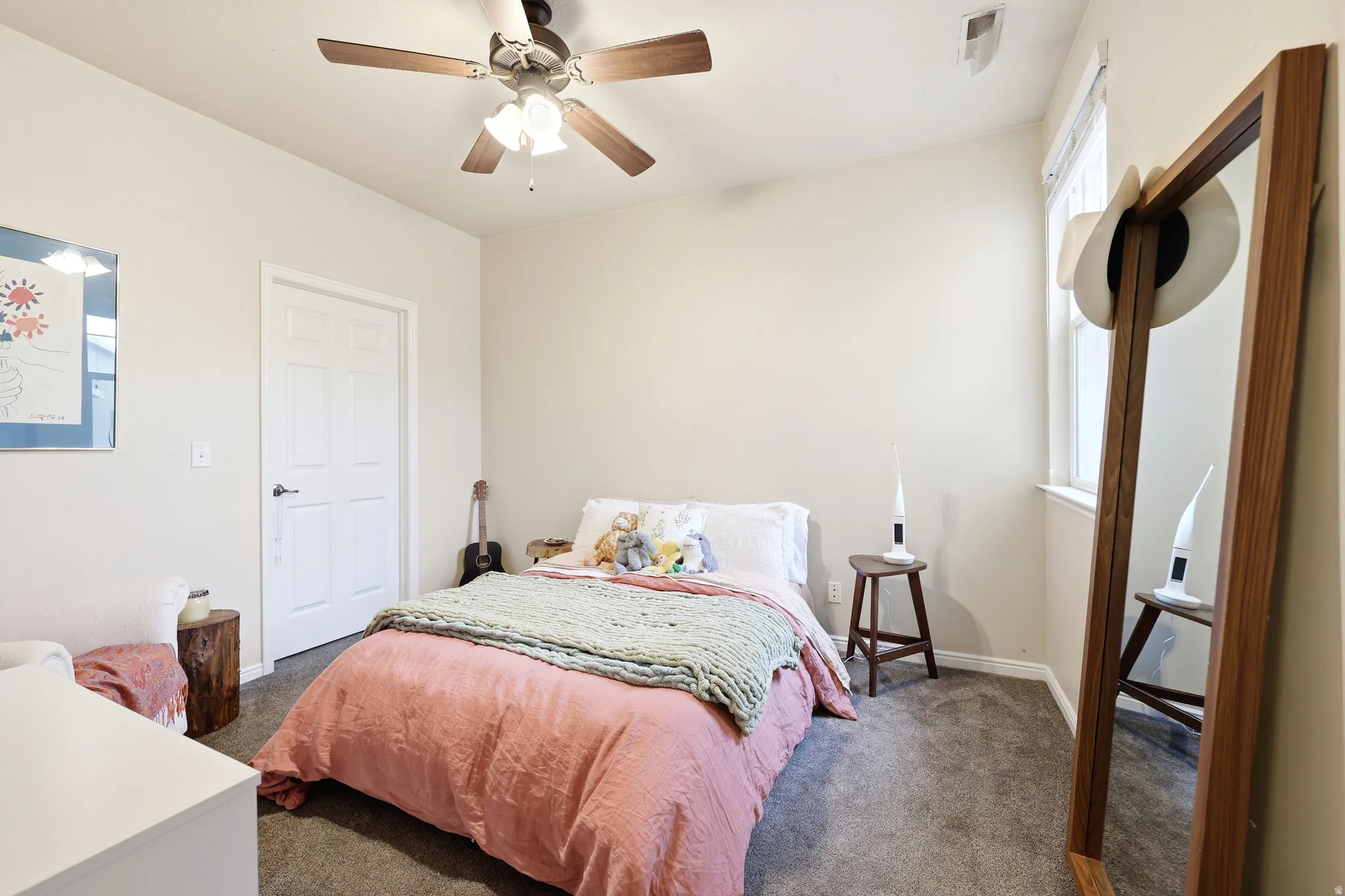 Bedroom with large walk-in closet and a ceiling fan