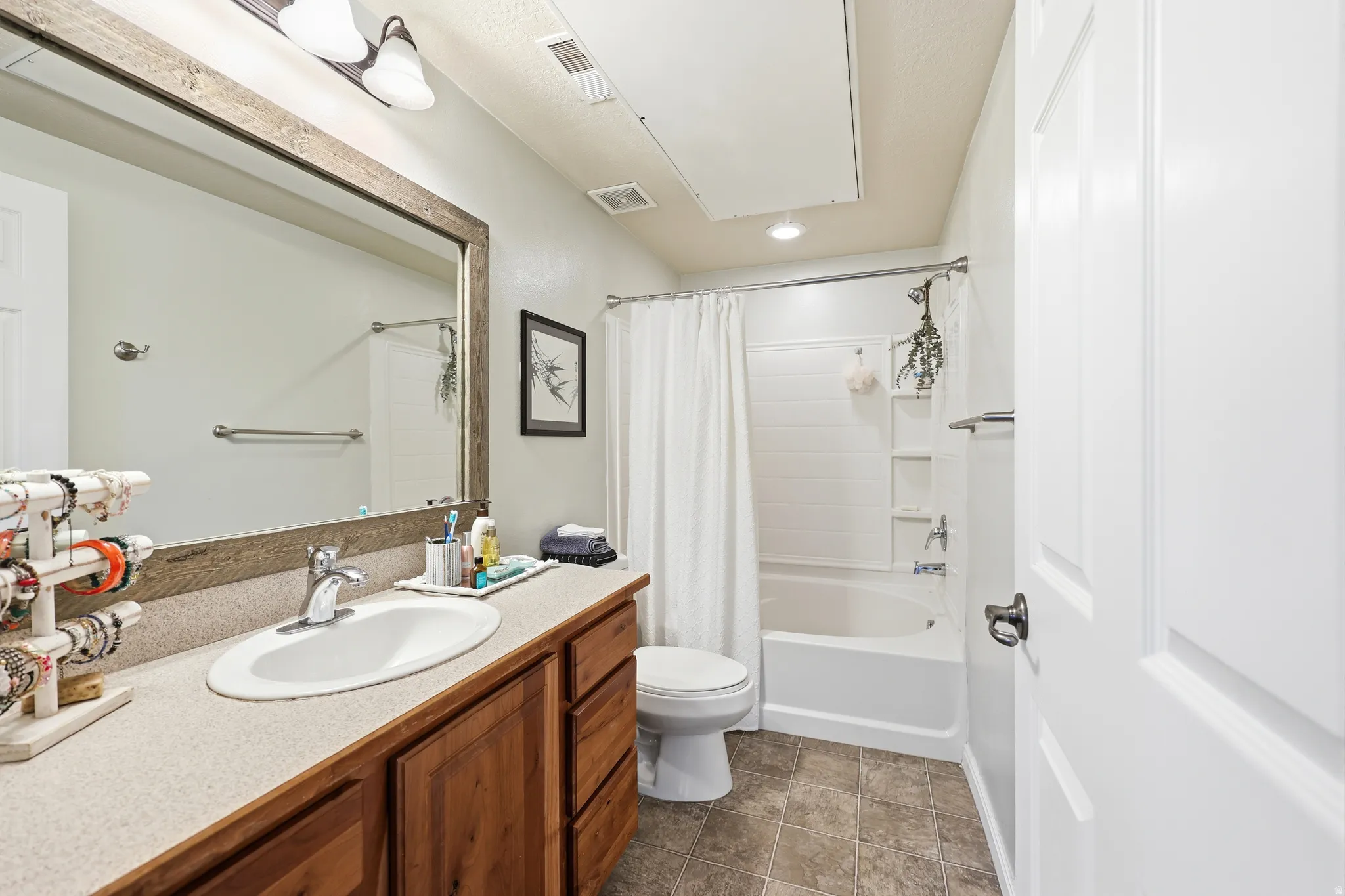 Bathroom with vanity, shower / bath combo, and recessed lighting