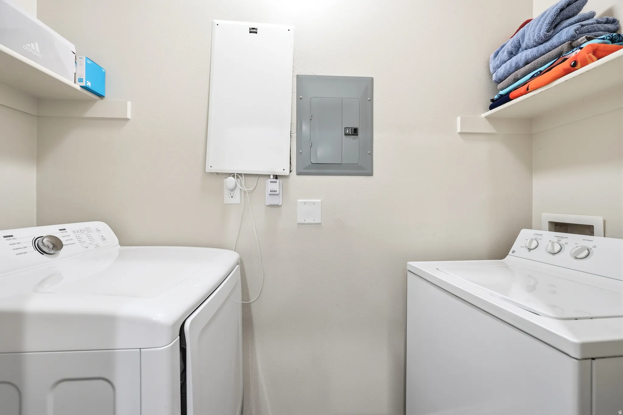 Laundry area with electric panel and separate washer and dryer
