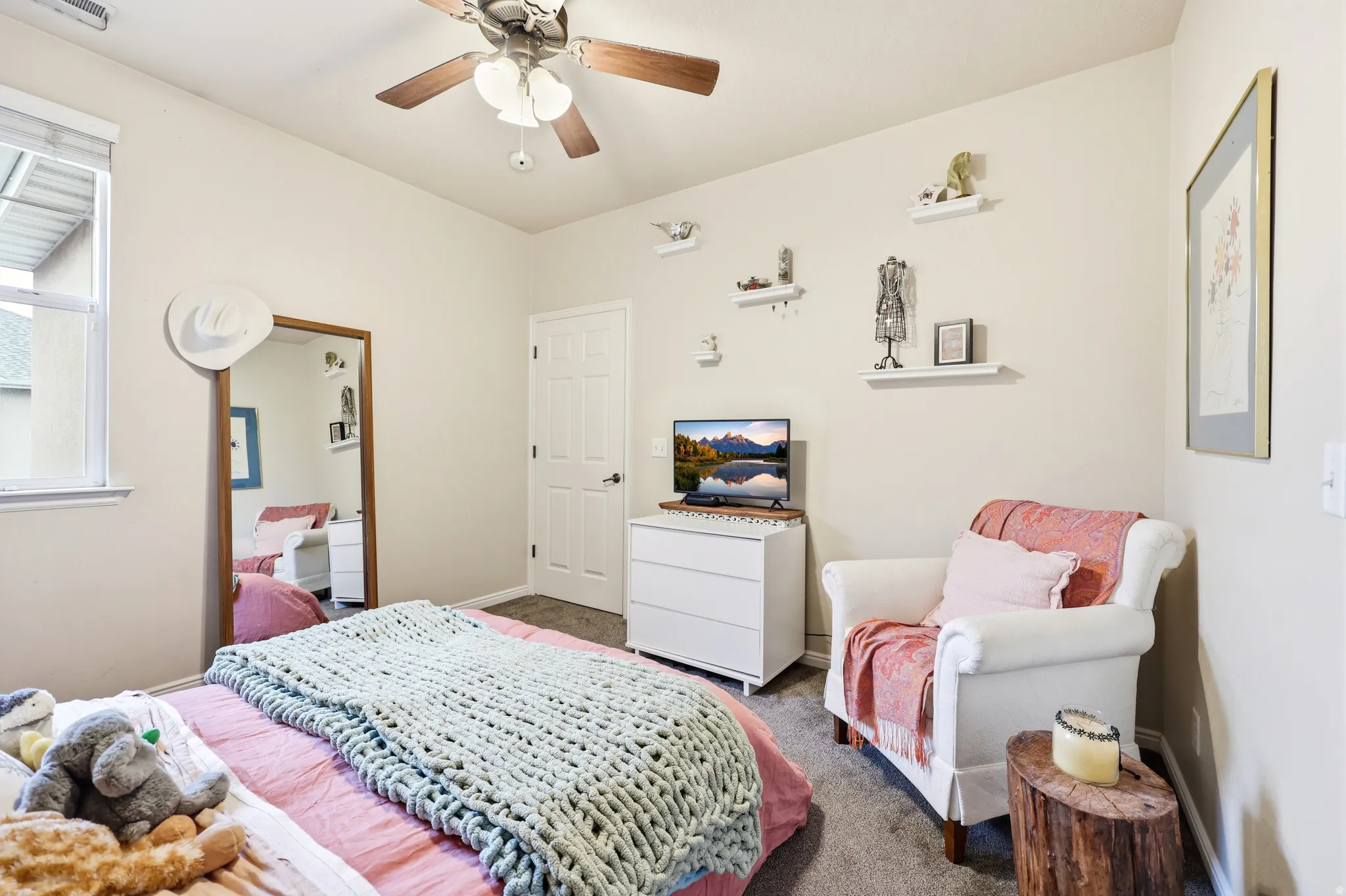 Bright well lit bedroom with ceiling fan