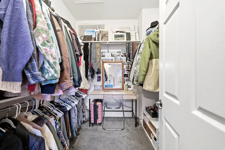 Walk in closet featuring light carpet and attic access