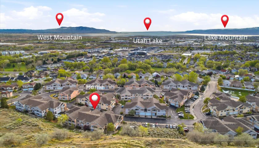 Aerial view of property and surrounding area with mountains and nearby suburban area