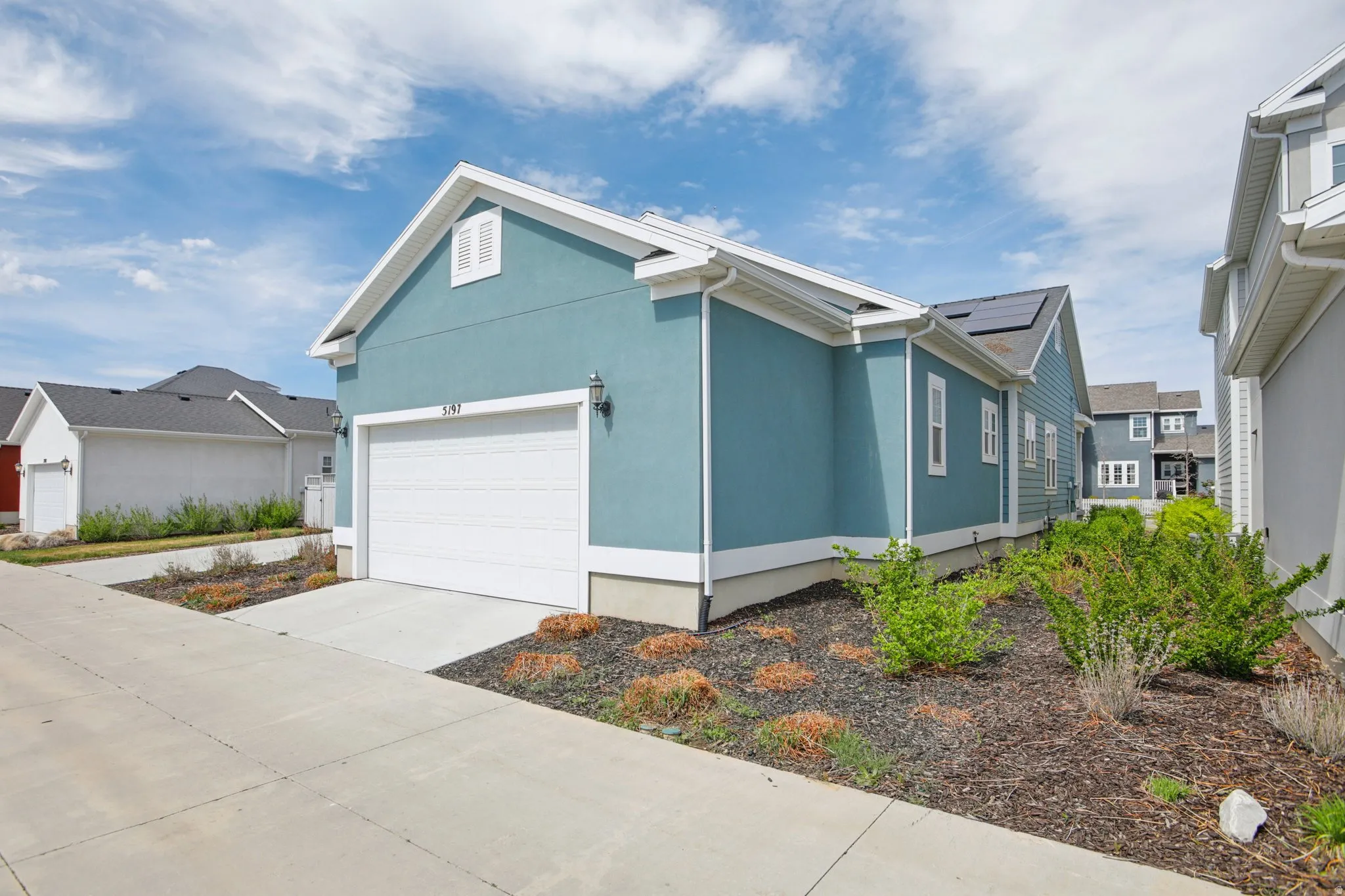 View of side of home featuring stucco siding, driveway, and a garage