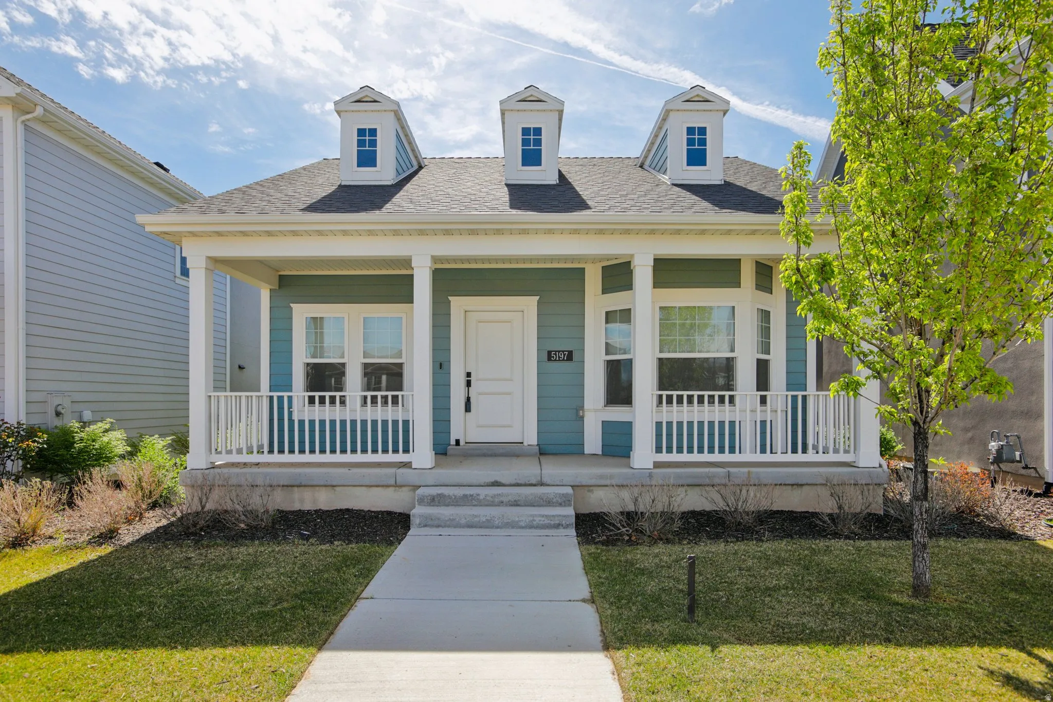 View of front of home featuring a front yard, a porch, and roof with shingles
