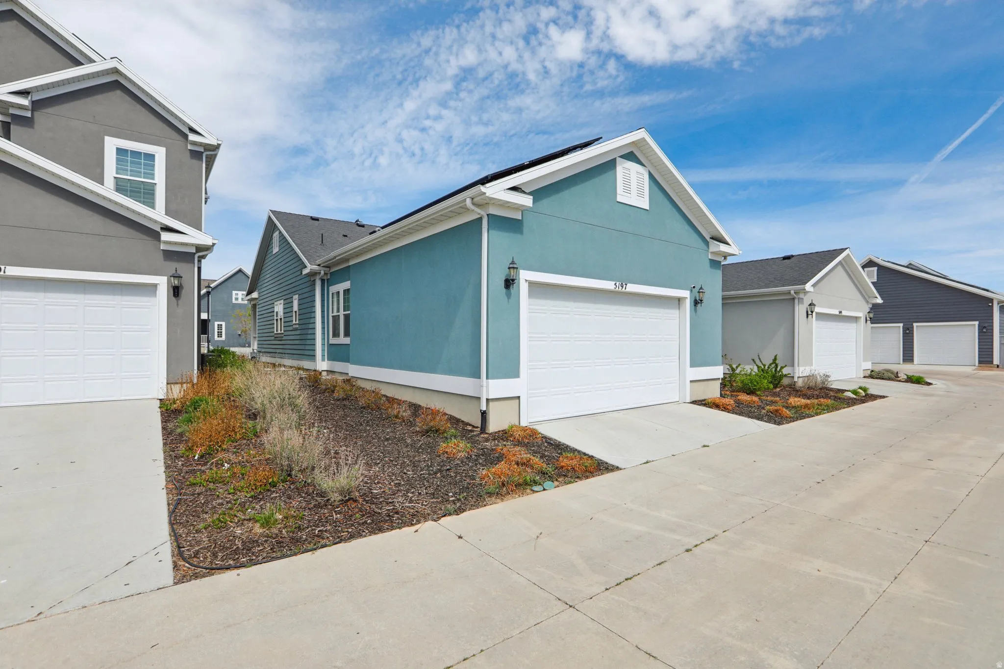 View of front of house featuring stucco siding, concrete driveway, and a garage