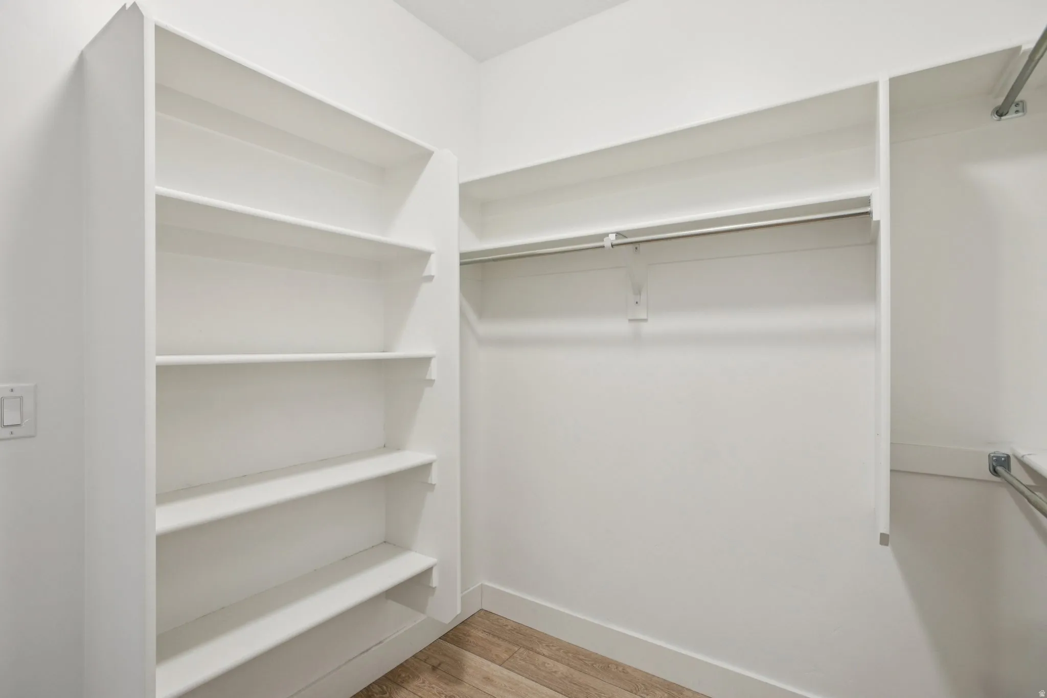 Walk in closet with light wood-style floors
