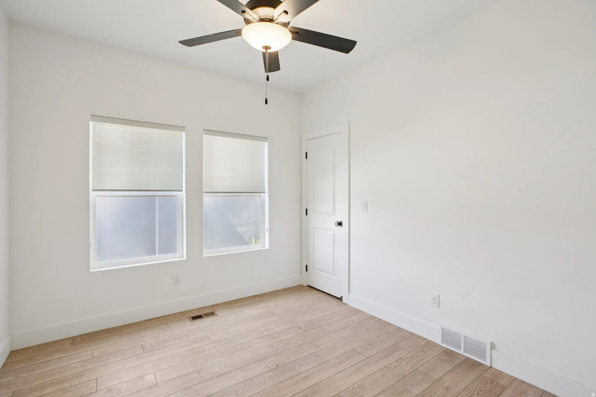 Spare room featuring light wood-style floors and a ceiling fan