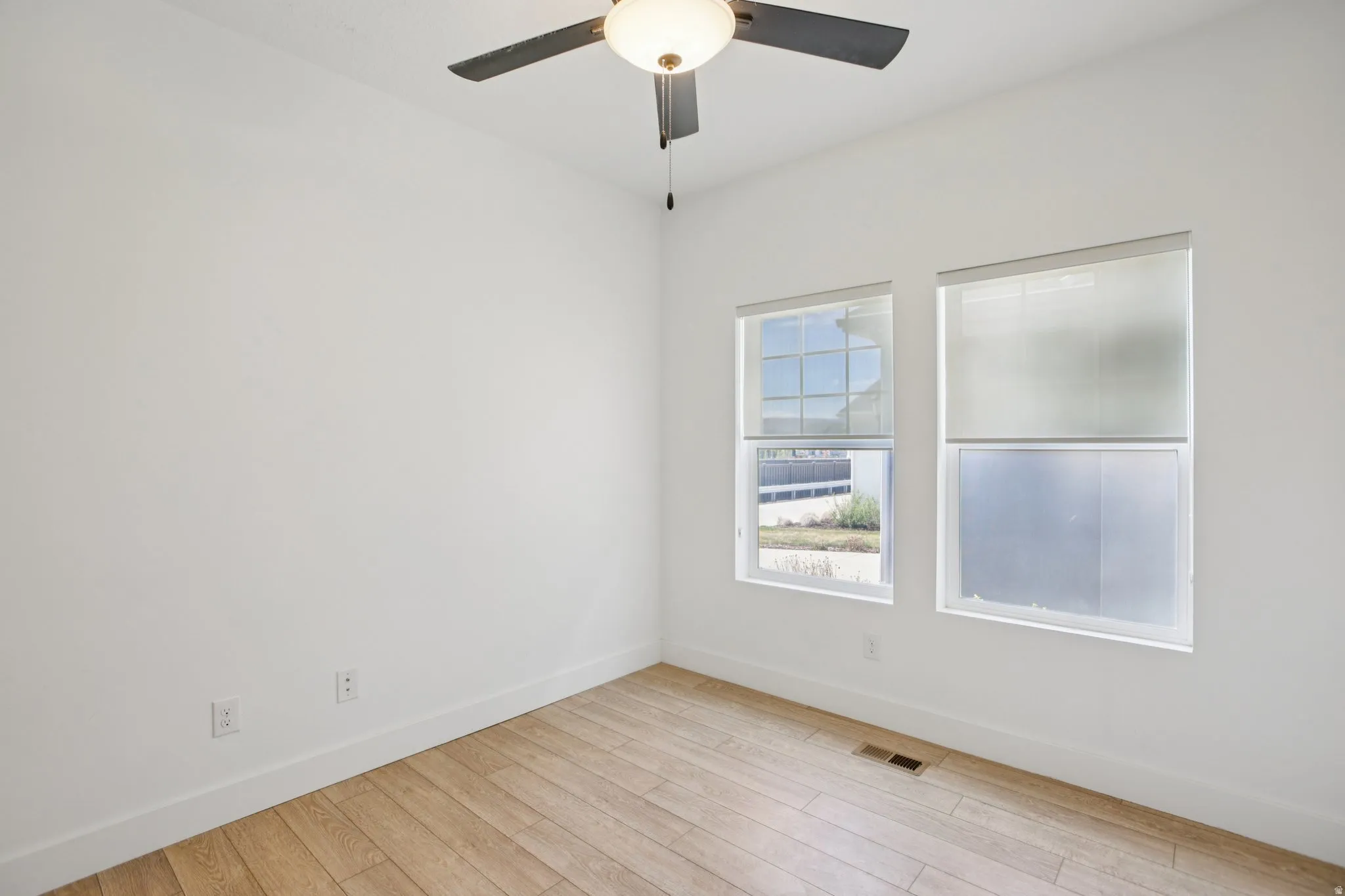 Spare room with light wood-type flooring and ceiling fan