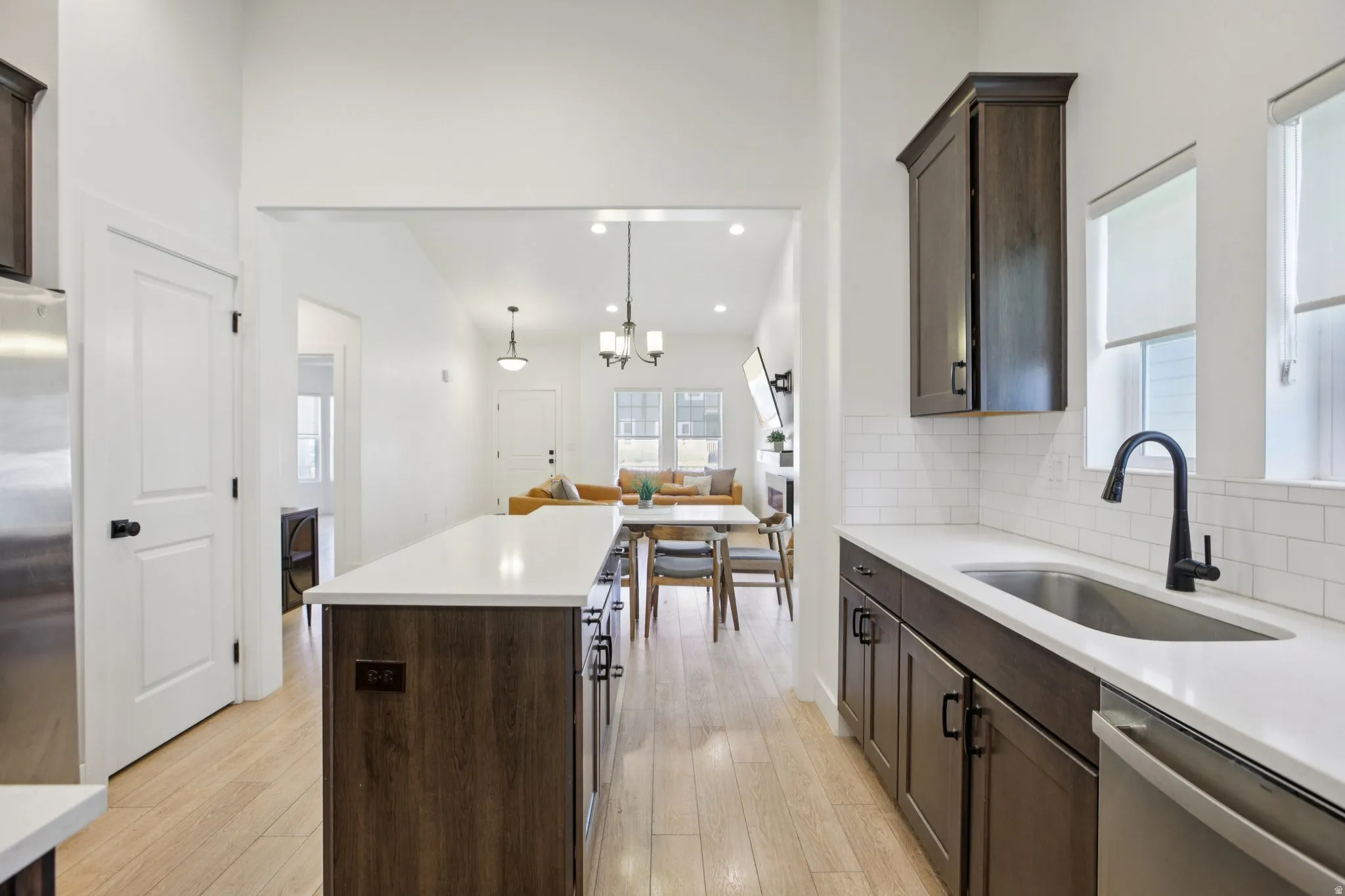 Kitchen with dark wood finish cabinetry, stainless steel appliances, backsplash, and a kitchen island