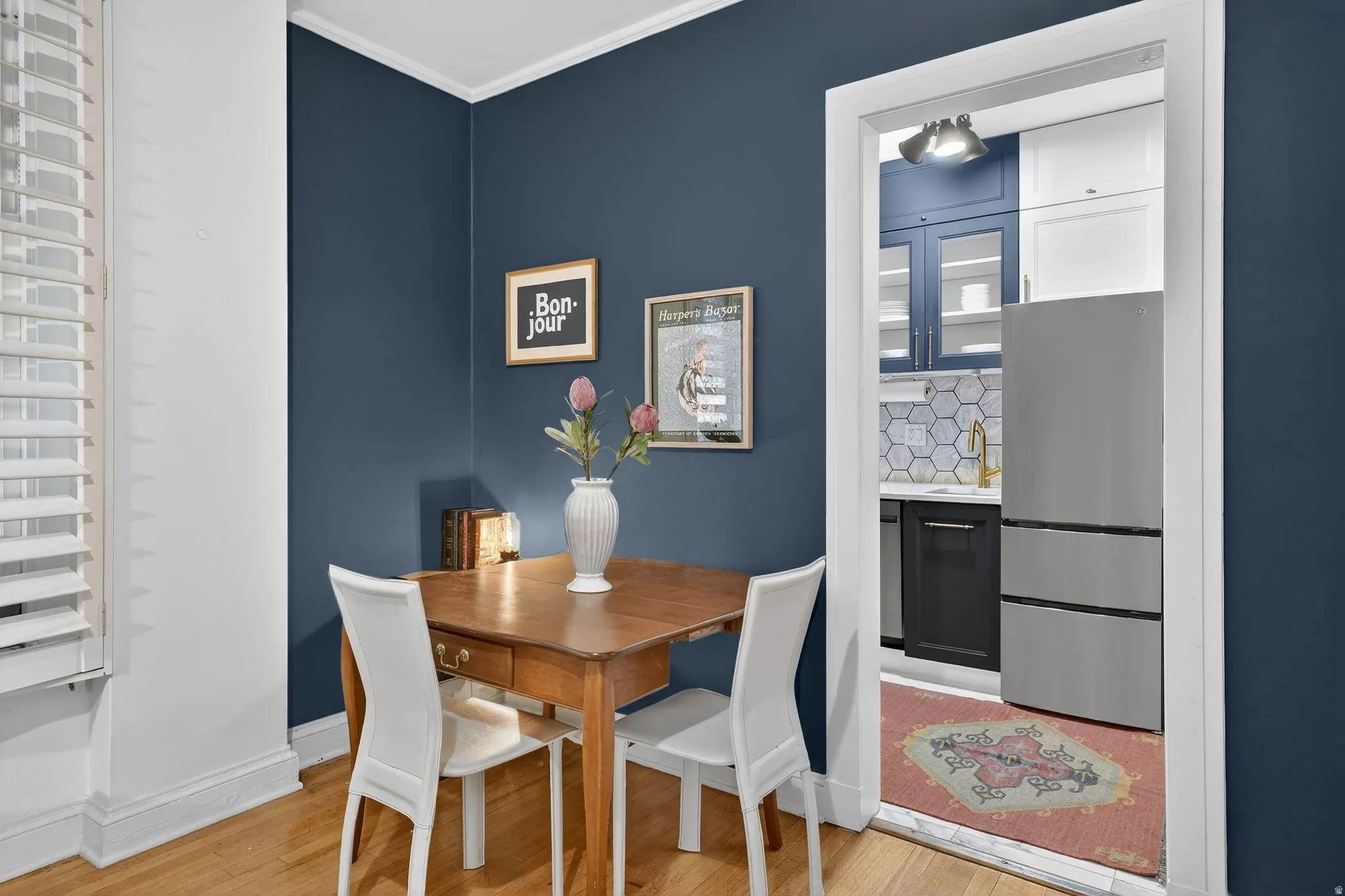 Dining space with crown molding and light wood-style floors