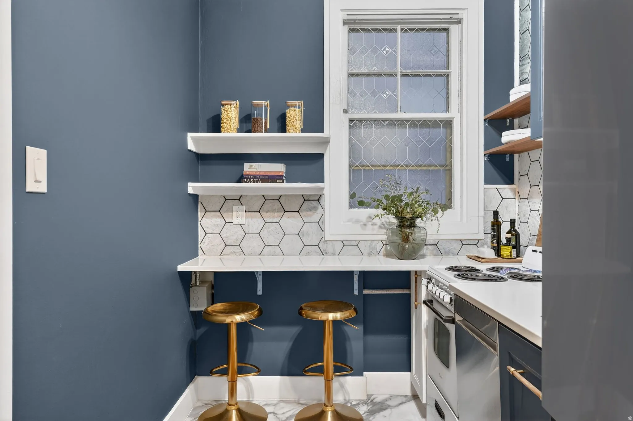 Kitchen with white range with electric stovetop, freestanding refrigerator, open shelves, backsplash, and light stone countertops