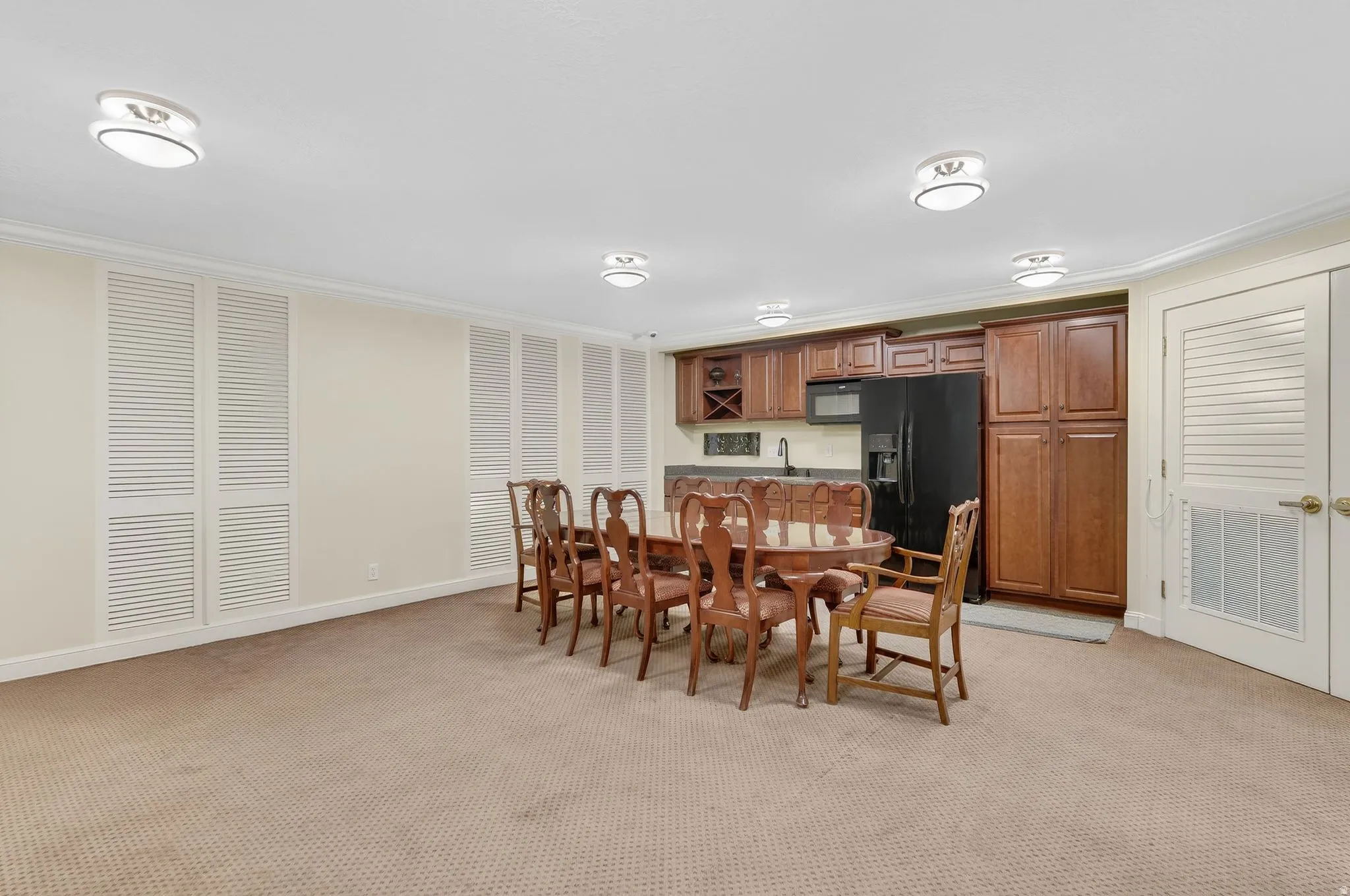 Dining space featuring light carpet and crown molding