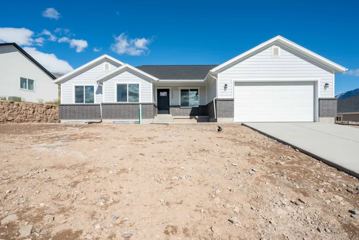 Ranch-style home with brick siding, covered porch, an attached garage, and concrete driveway