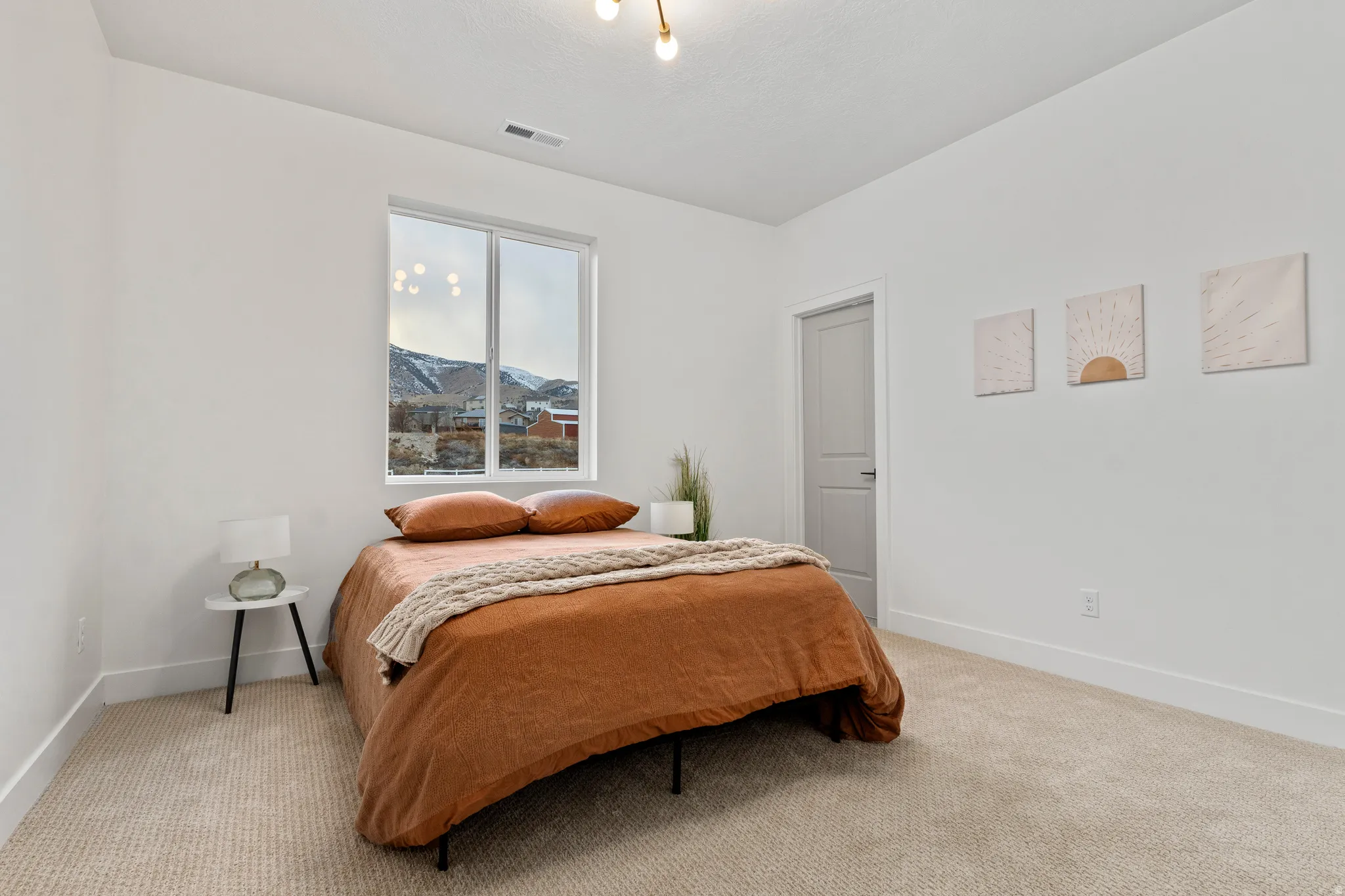 Bedroom with light carpet and a mountain view
