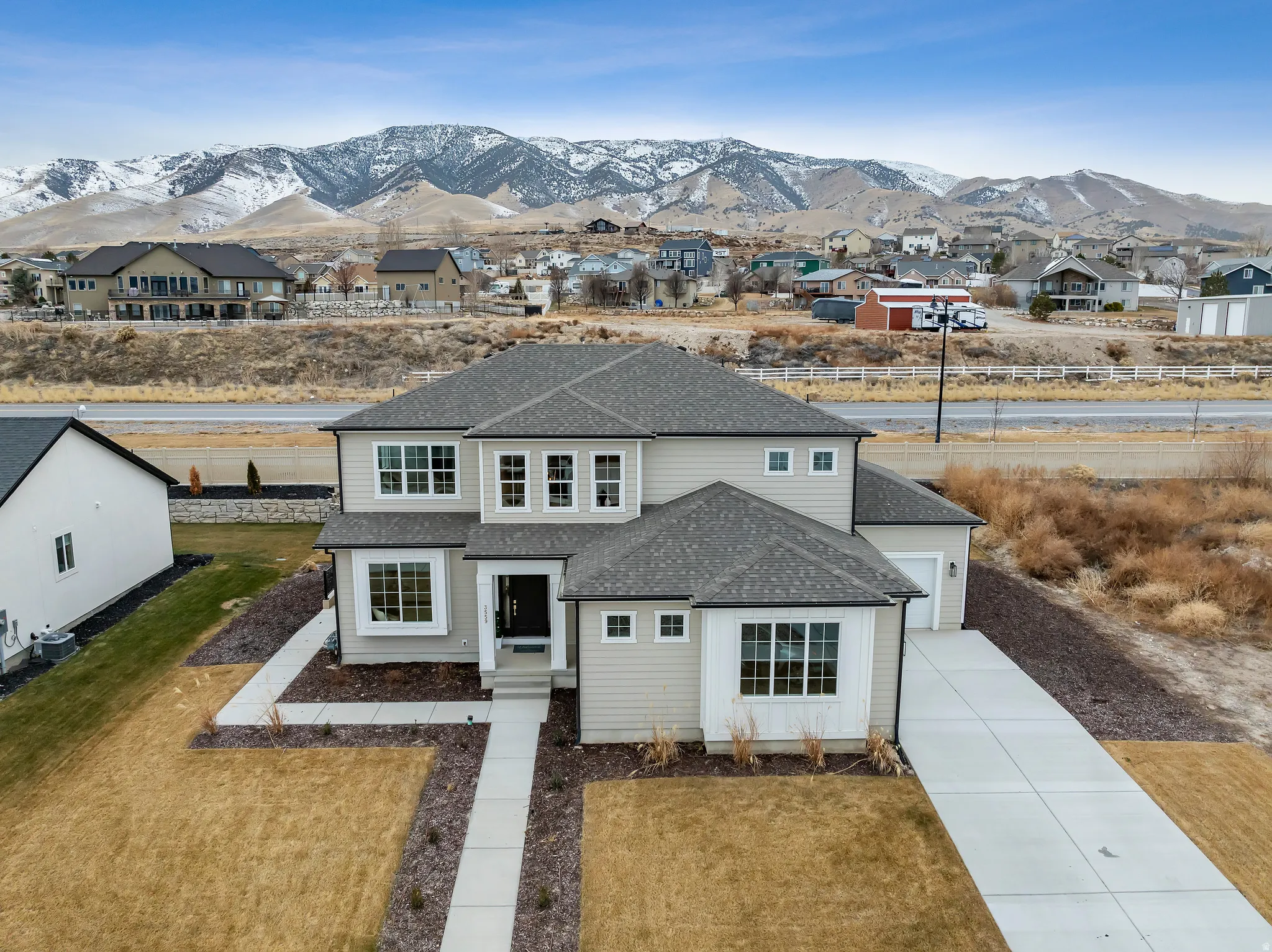 View of front facade featuring roof with shingles, a front lawn, a mountain view, and a residential view