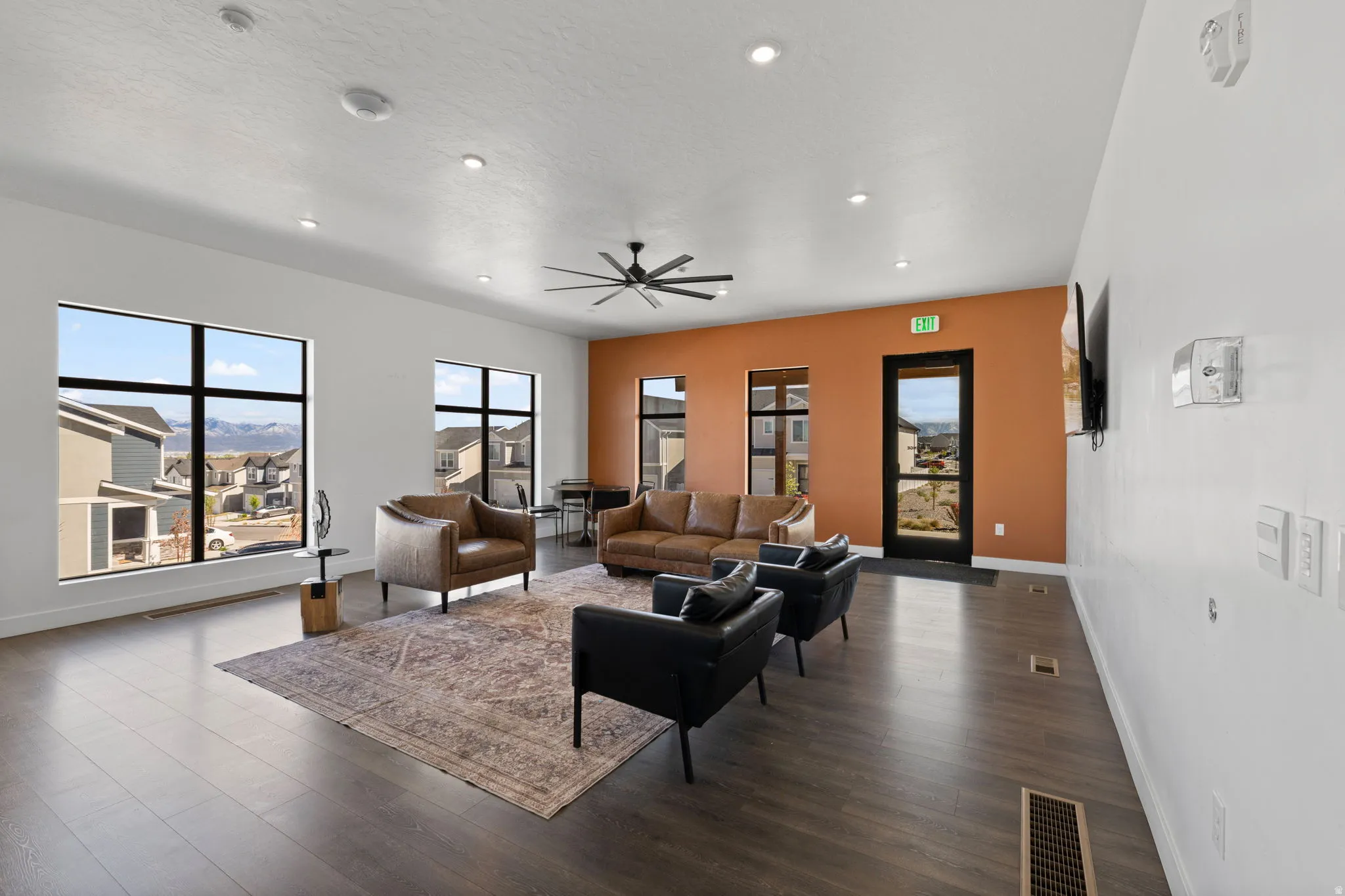 Living room featuring dark wood-type flooring, plenty of natural light, ceiling fan, and recessed lighting