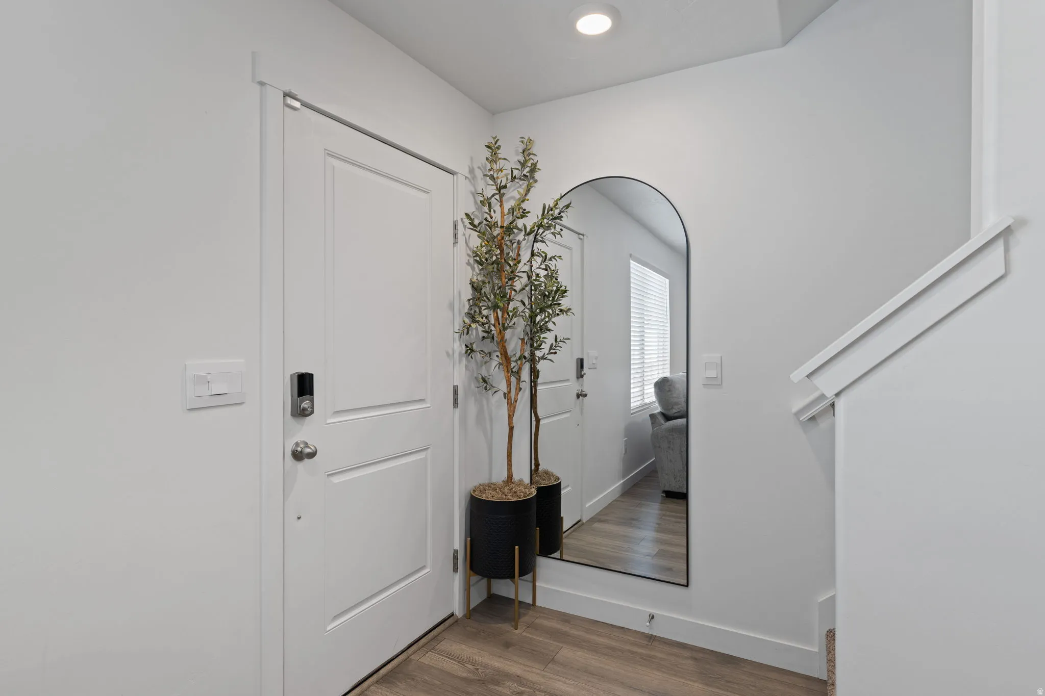 Entrance foyer featuring light wood-style flooring, recessed lighting, and arched walkways