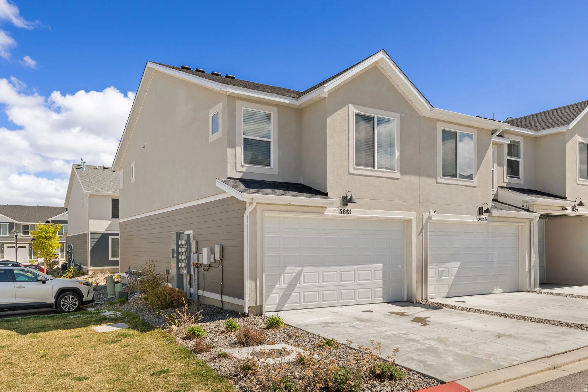 View of property exterior with a garage, concrete driveway, a residential view, and stucco siding