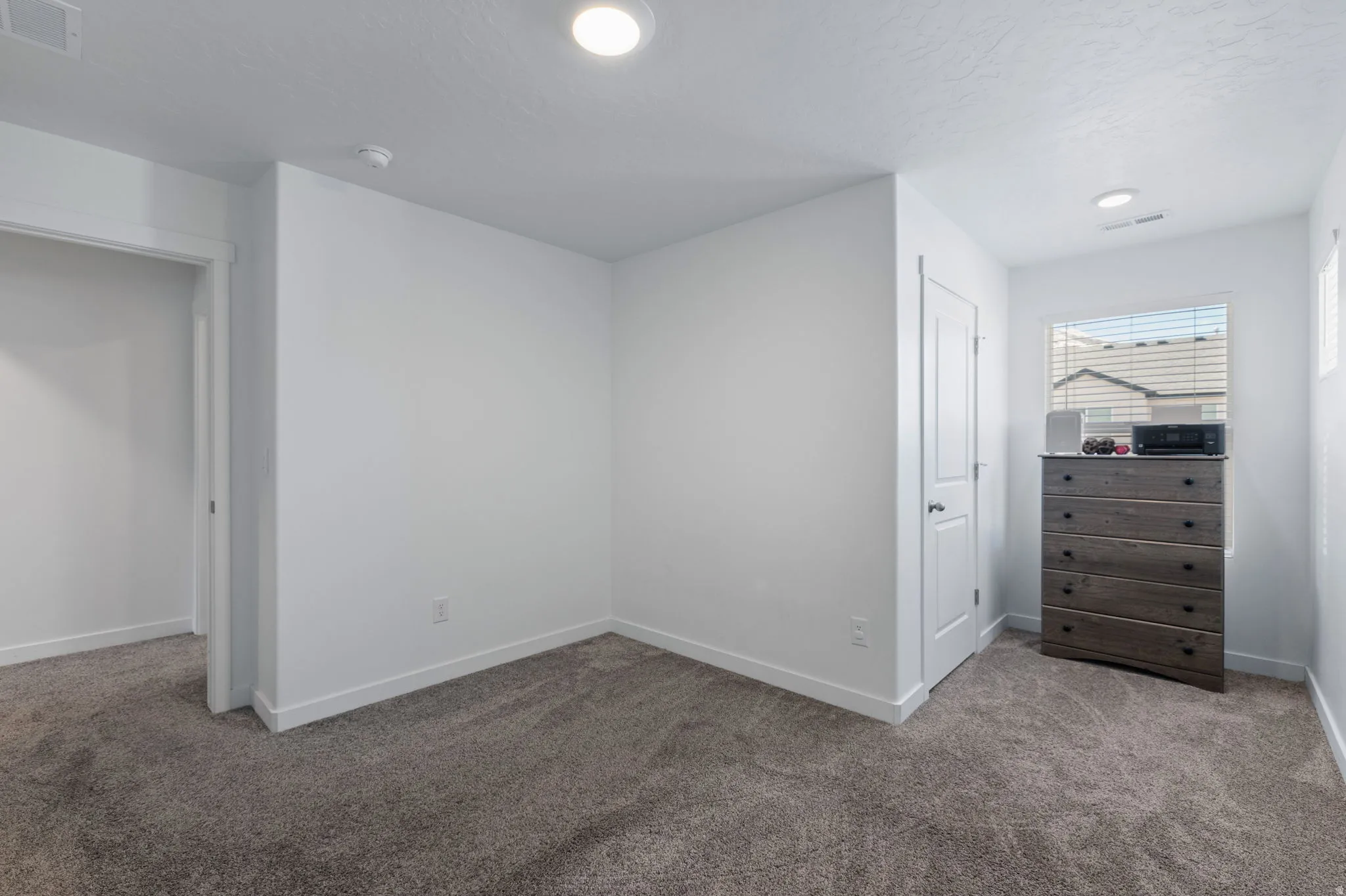 Unfurnished bedroom featuring carpet floors and a textured ceiling