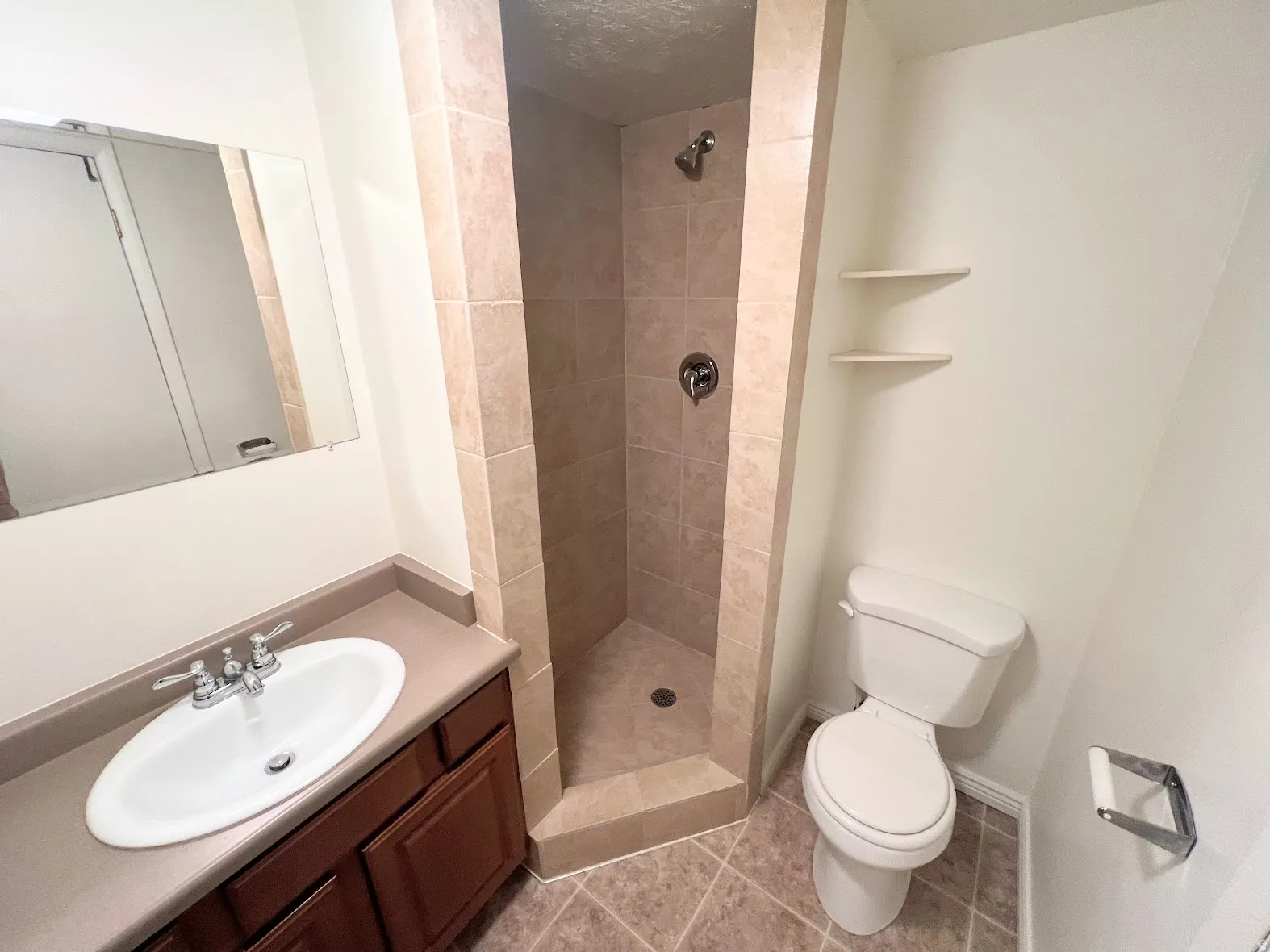 Bathroom with vanity, a stall shower, and light tile patterned flooring