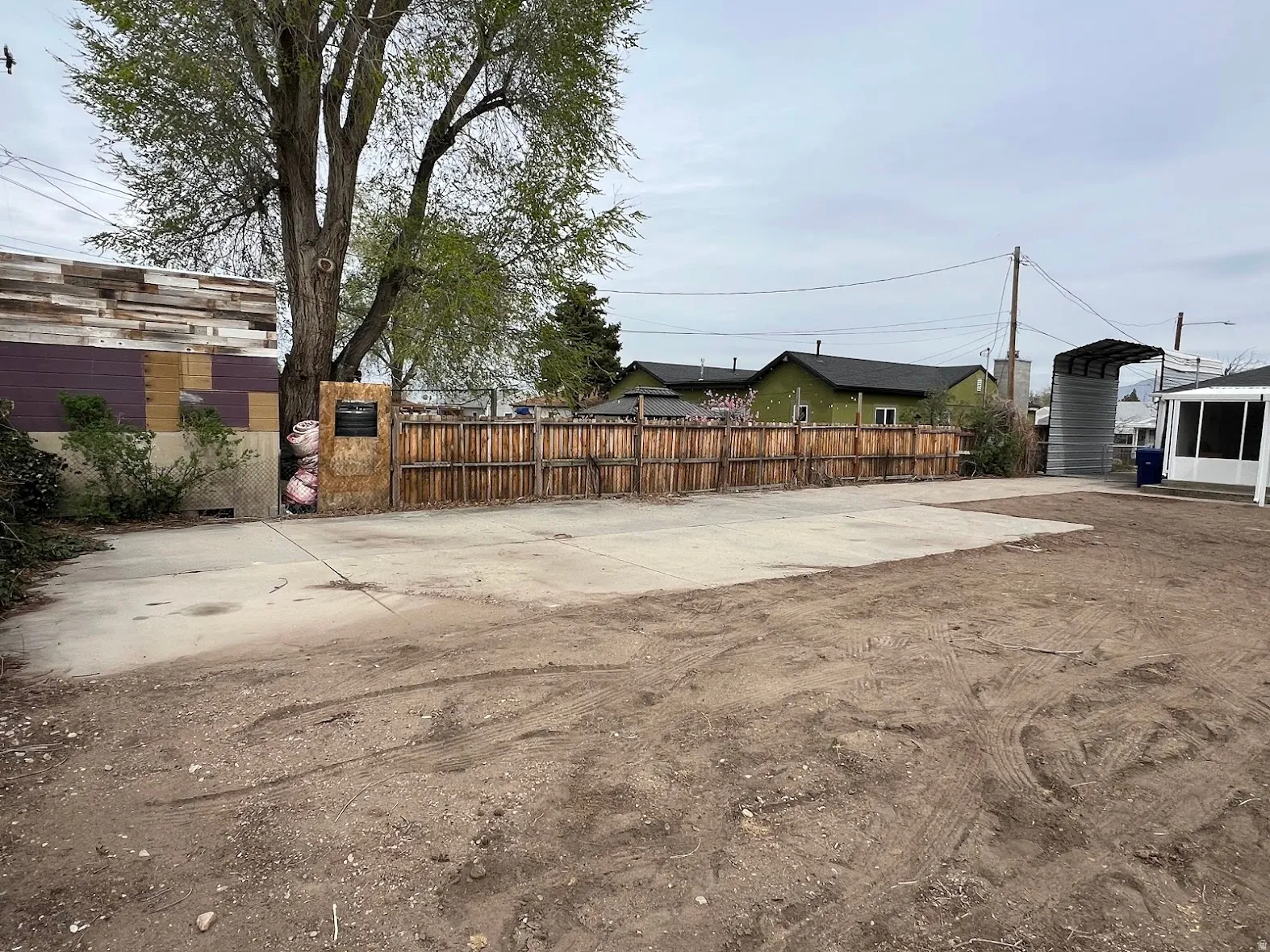View of yard featuring a detached carport and concrete driveway