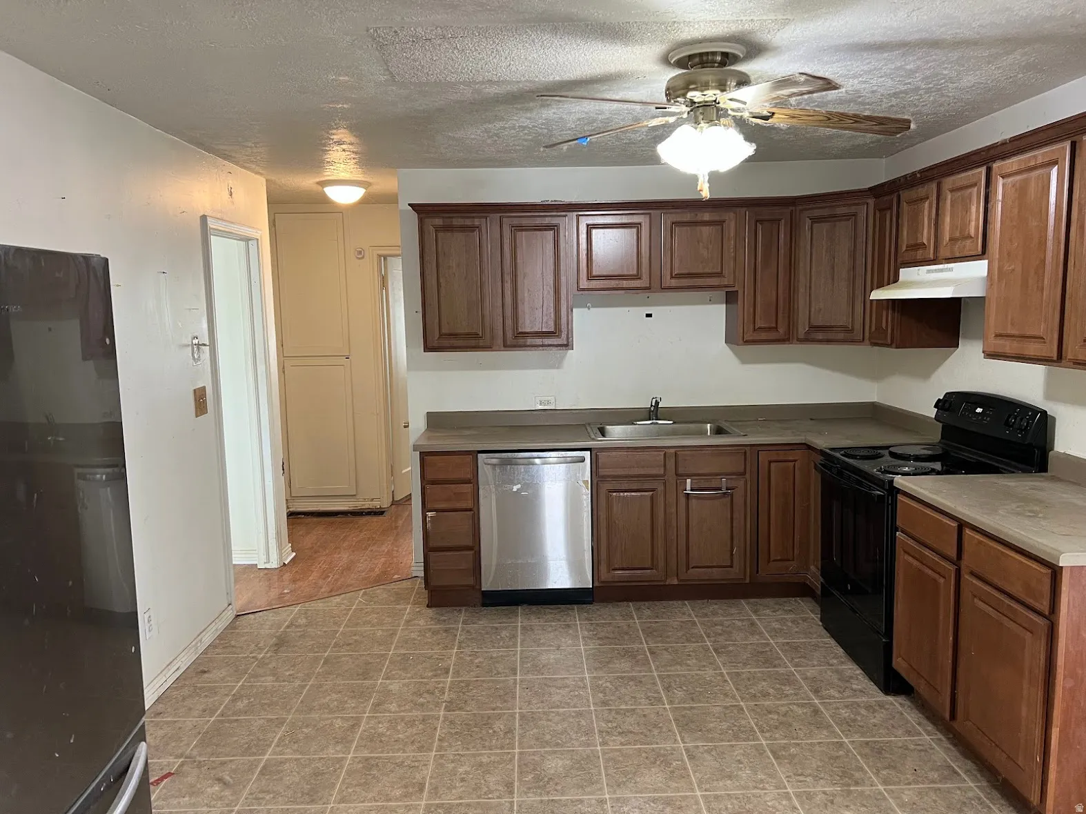 Kitchen featuring black appliances, a textured ceiling, and ceiling fan