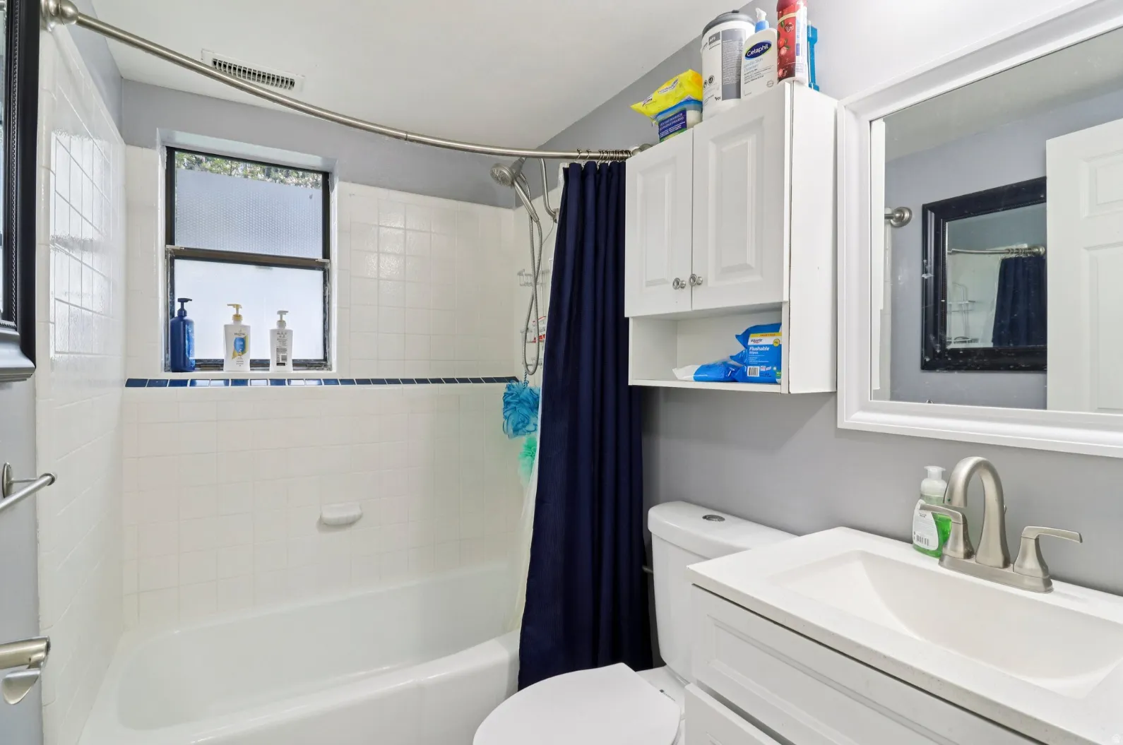 Full bath featuring vanity and shower / bathtub combination with curtain